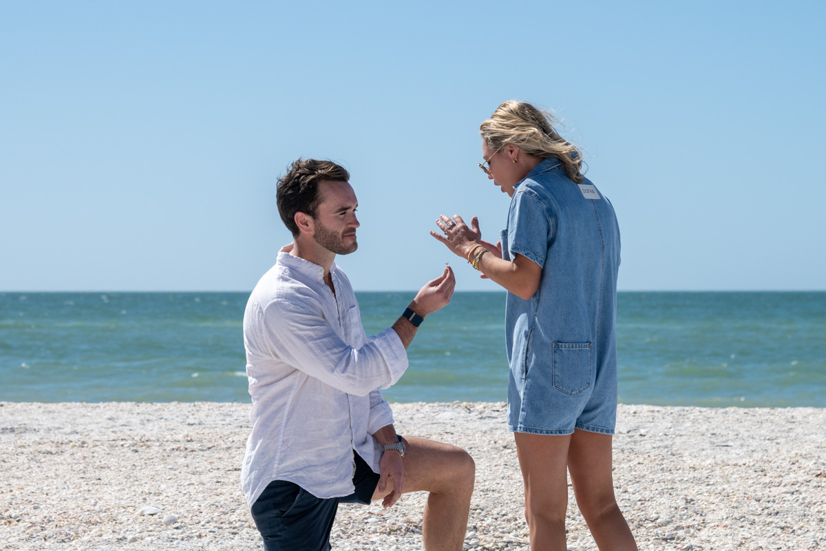 man holds out engagement ring to girlfriend