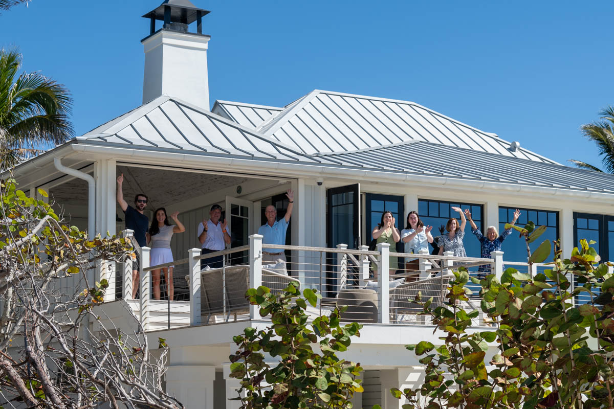 family on balcony cheers at