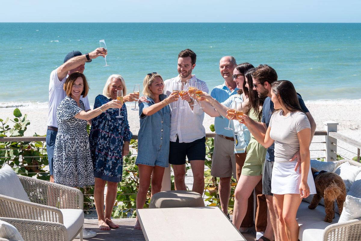 family gathers around a table with glasses of champagne to celebrate