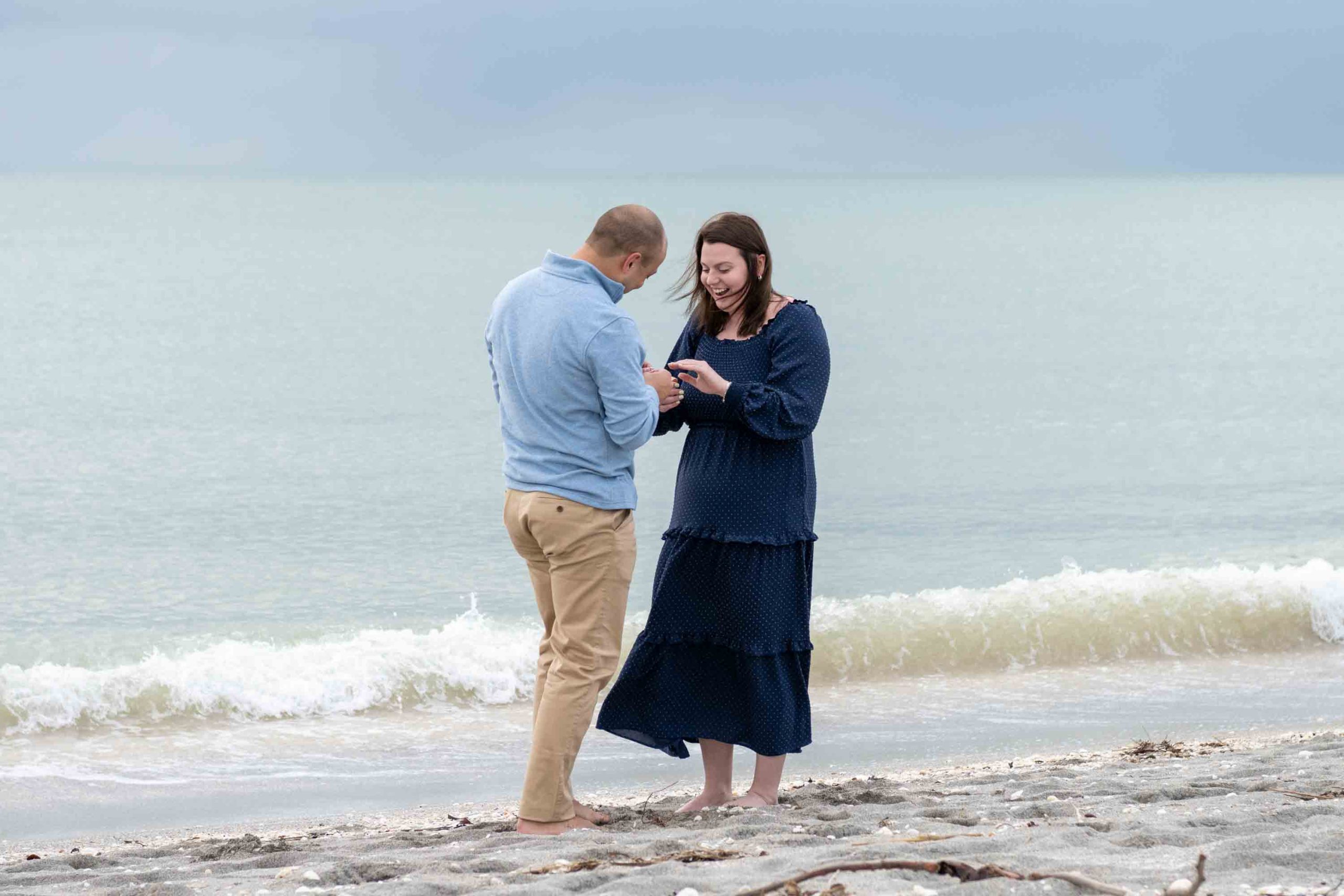 woman is in shock as she looks at her new engagement ring after surprise proposal