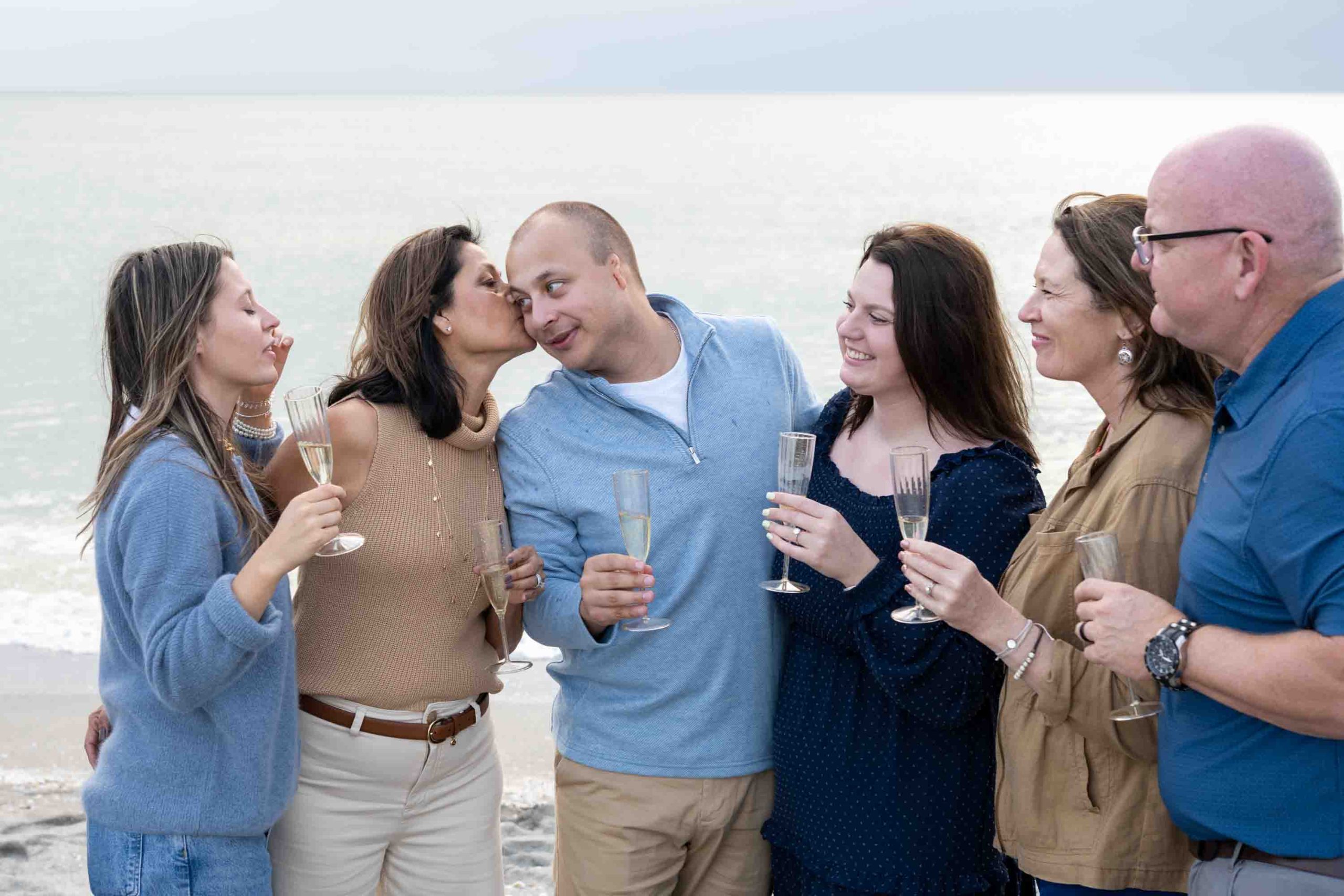 man's mother kisses his cheek in happiness of their engagement