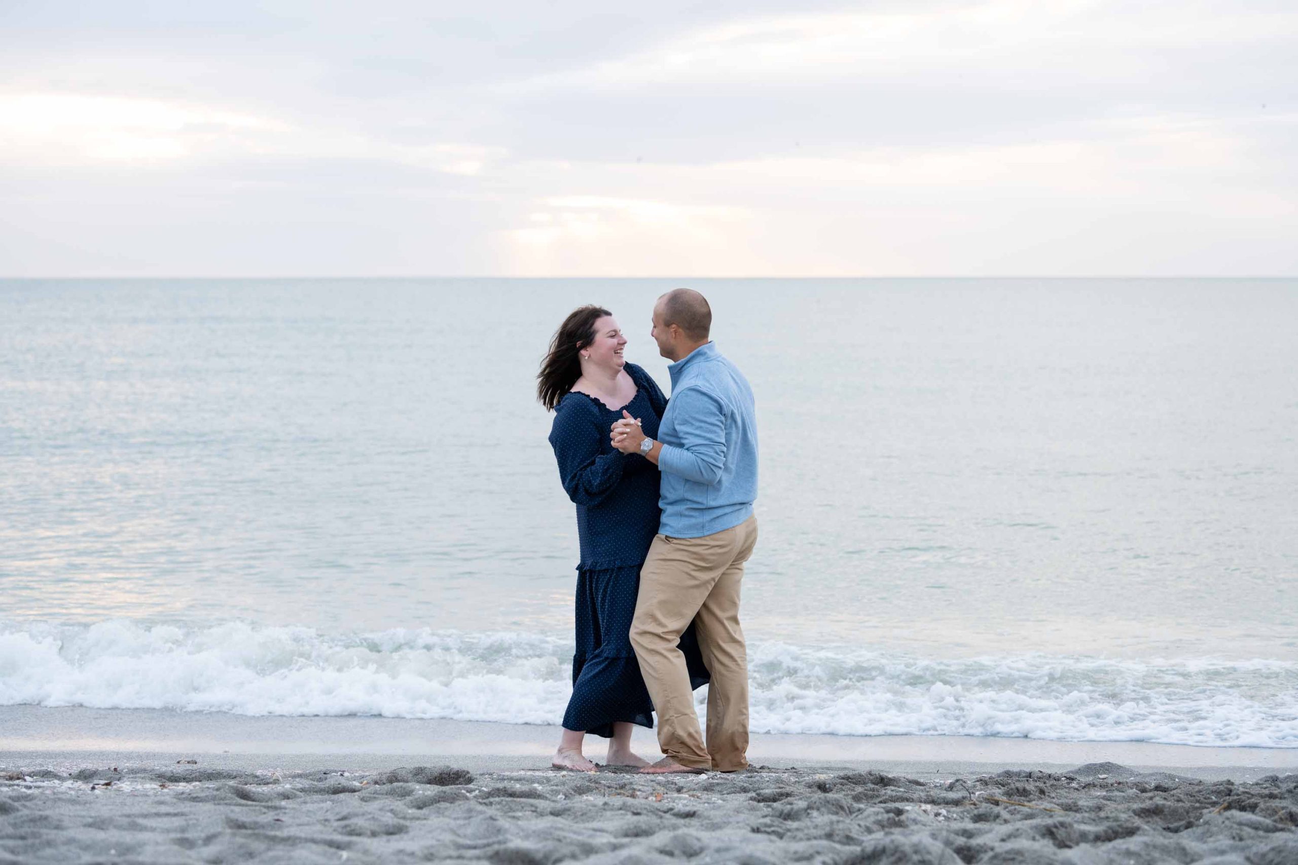 newly engaged couple dance on the beach