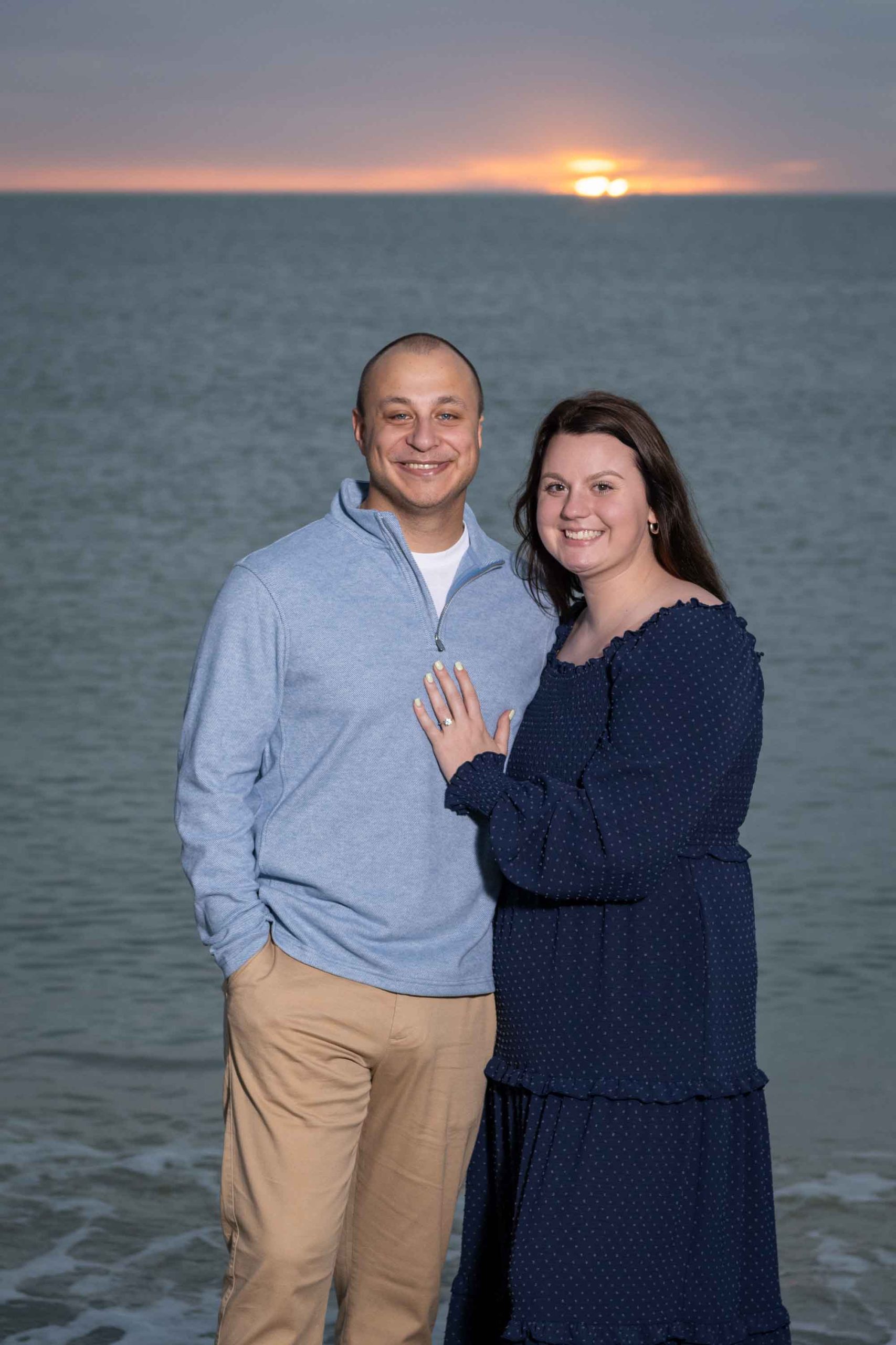 woman shows off her engagement ring by putting her hand on her fiance's chest