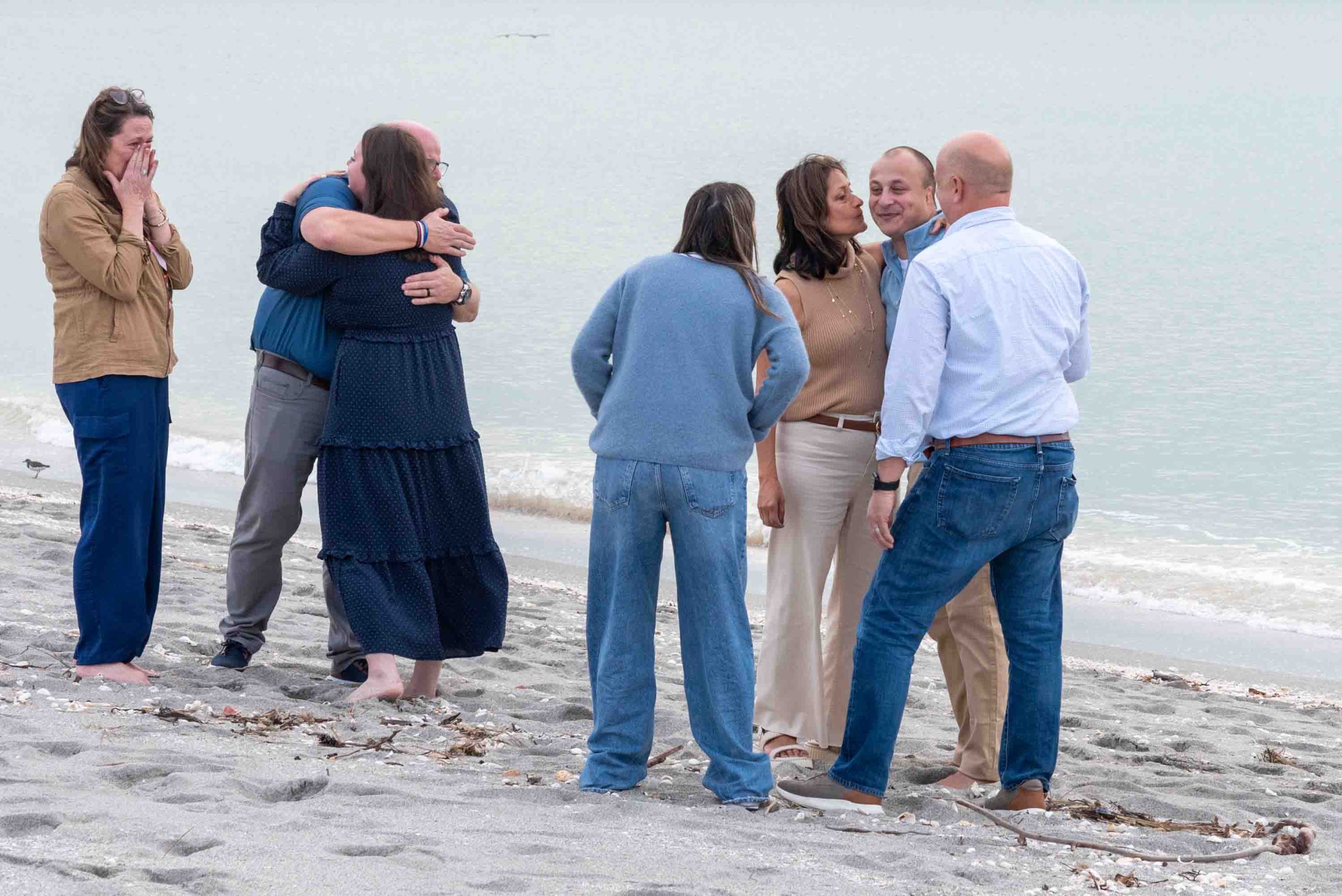families hugging on the beach