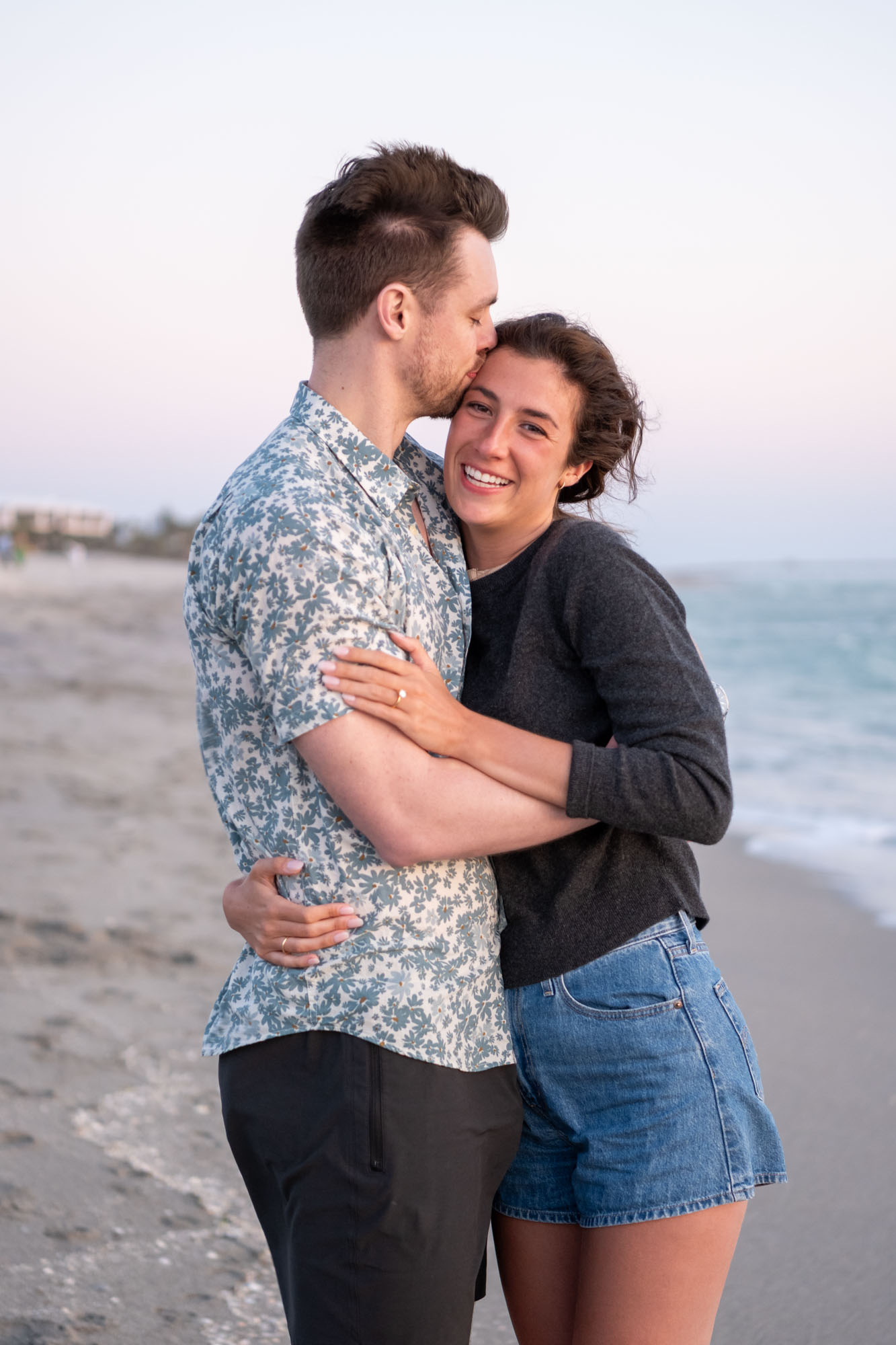 guy kisses is girlfriend's forehead as she smiles