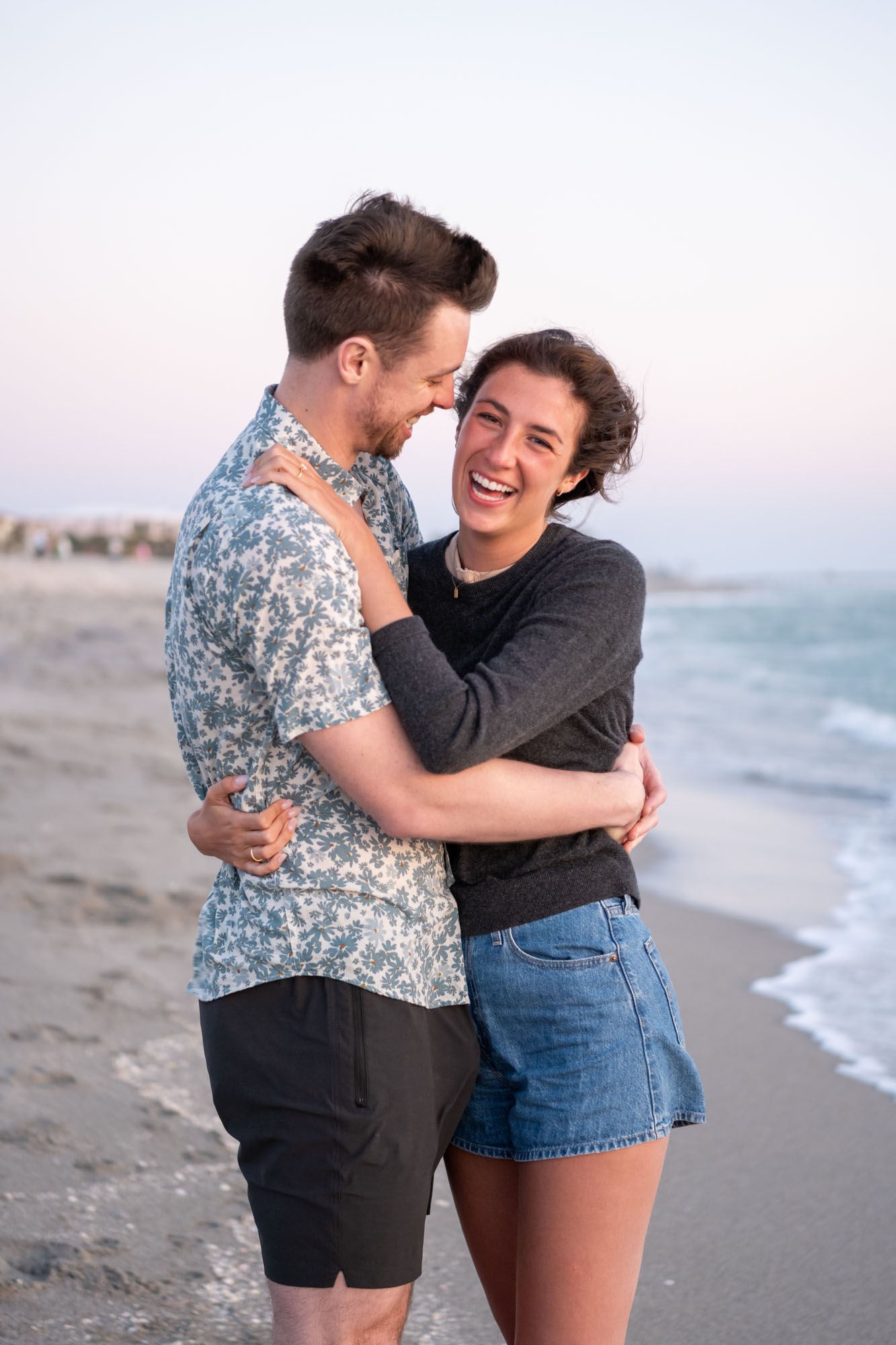 girl laughs in happiness as her fiance holds her