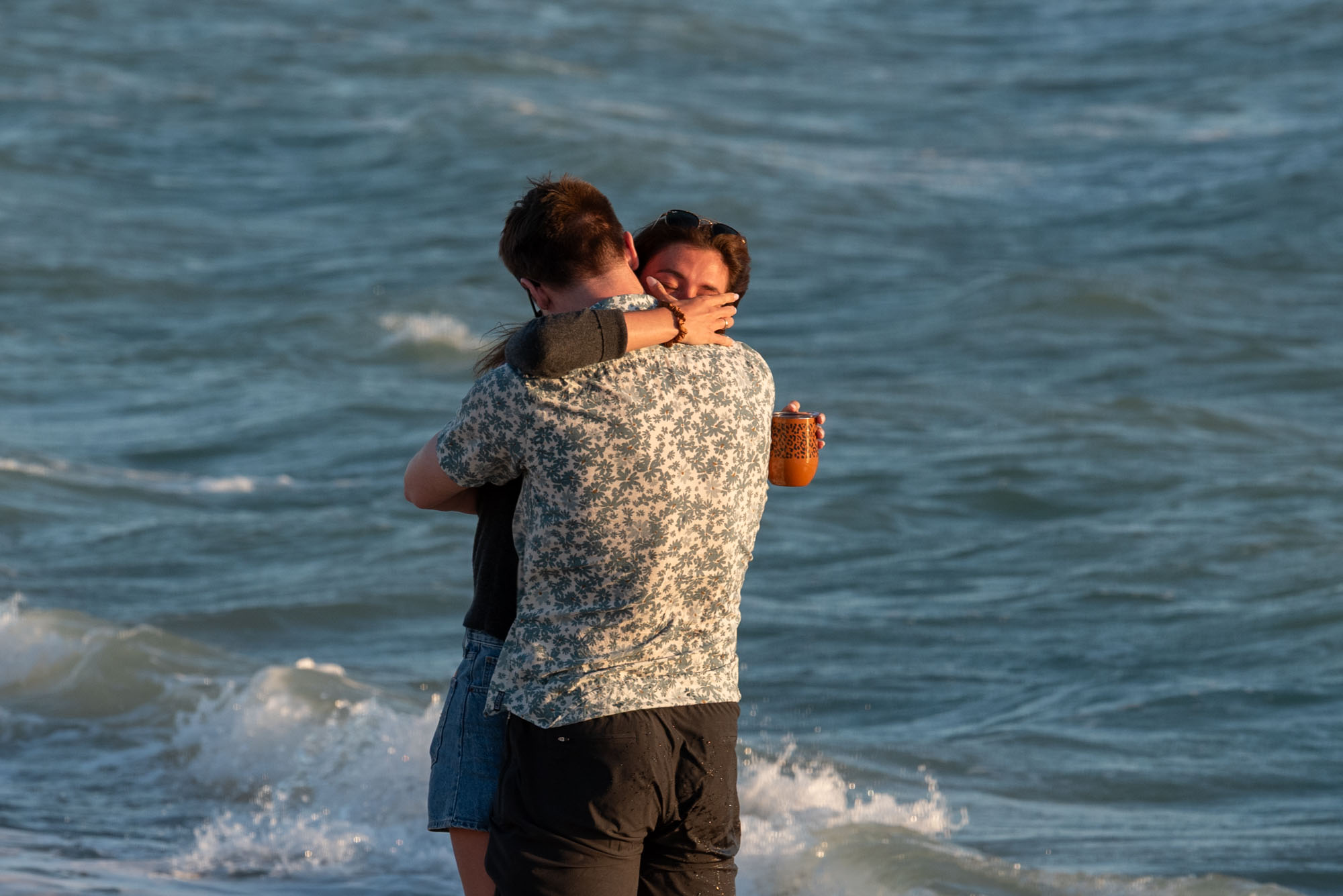 girl wipes her eyes as she hugs her boyfriend who just proposed