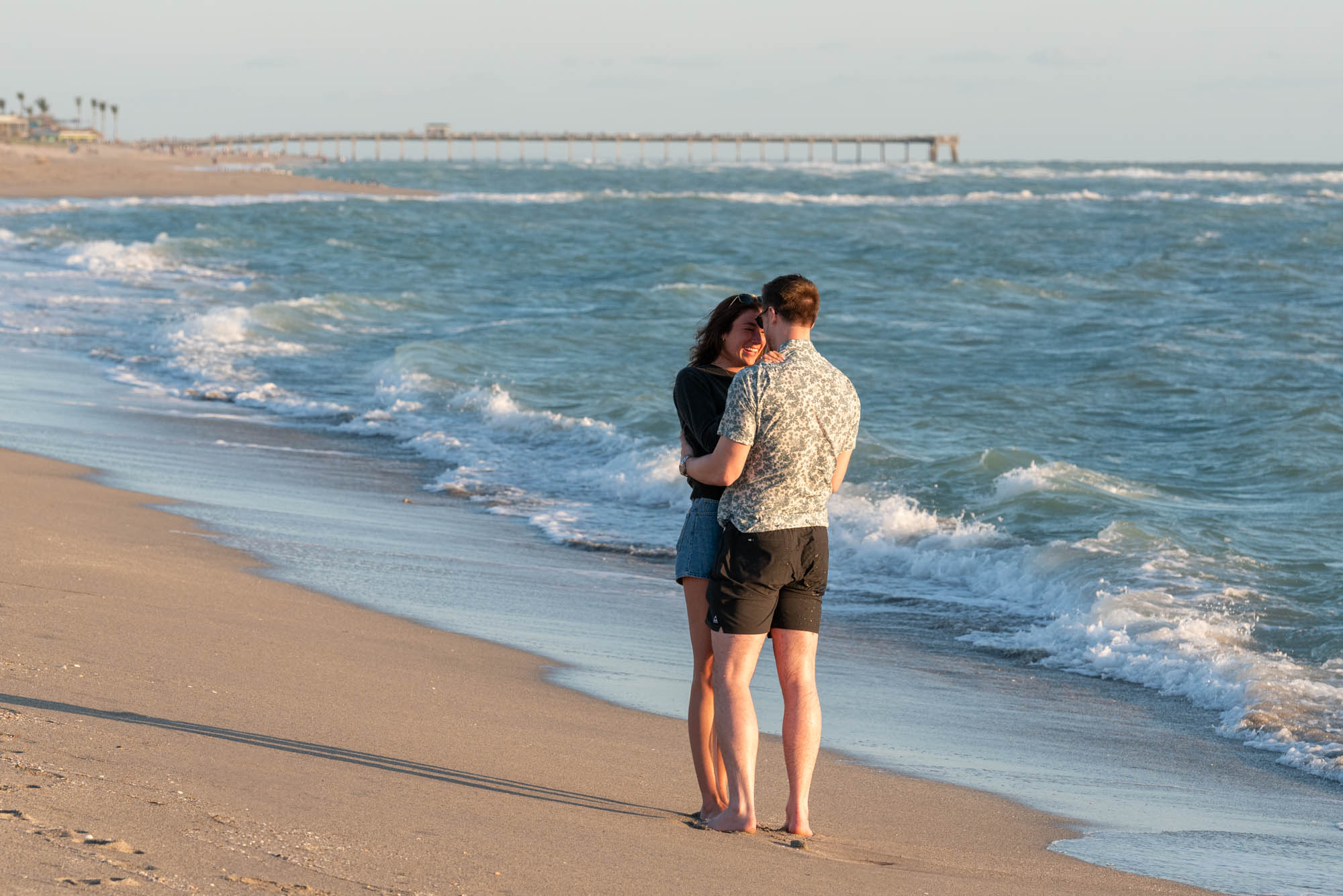 newly engaged couple take a quiet moment by themselves on the beach