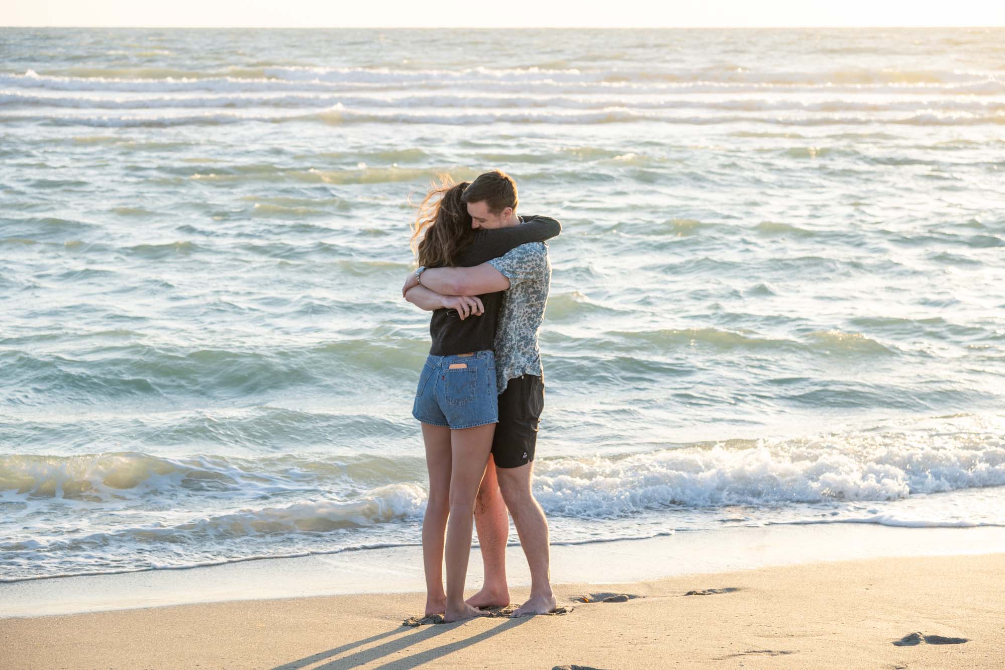 man and woman on the beach hug