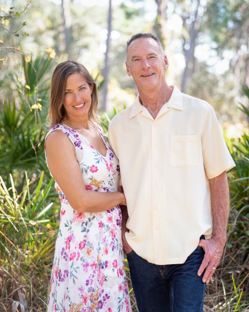 Stephanie and Mike stand together in a park