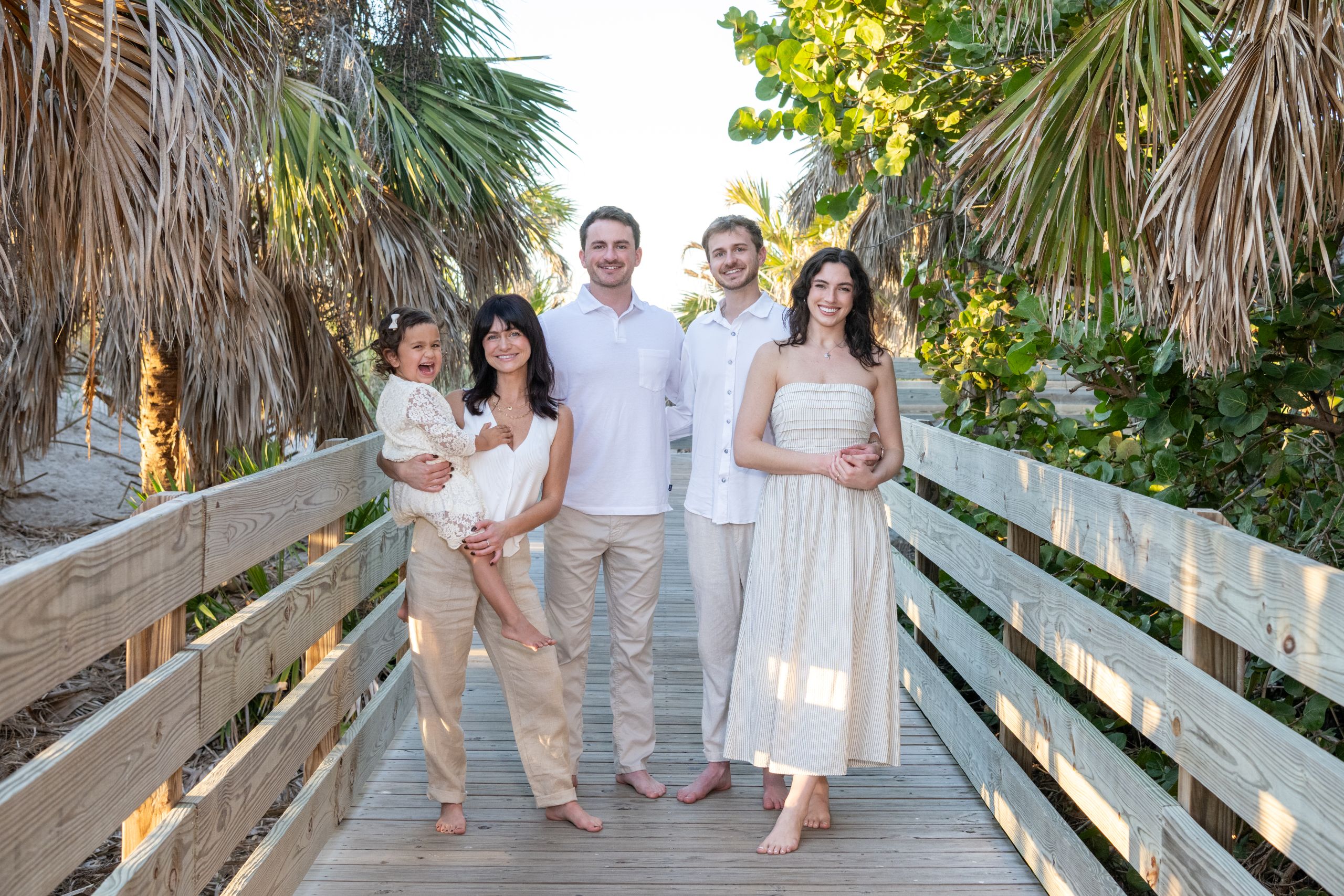 siblings stand together on the boardwalk