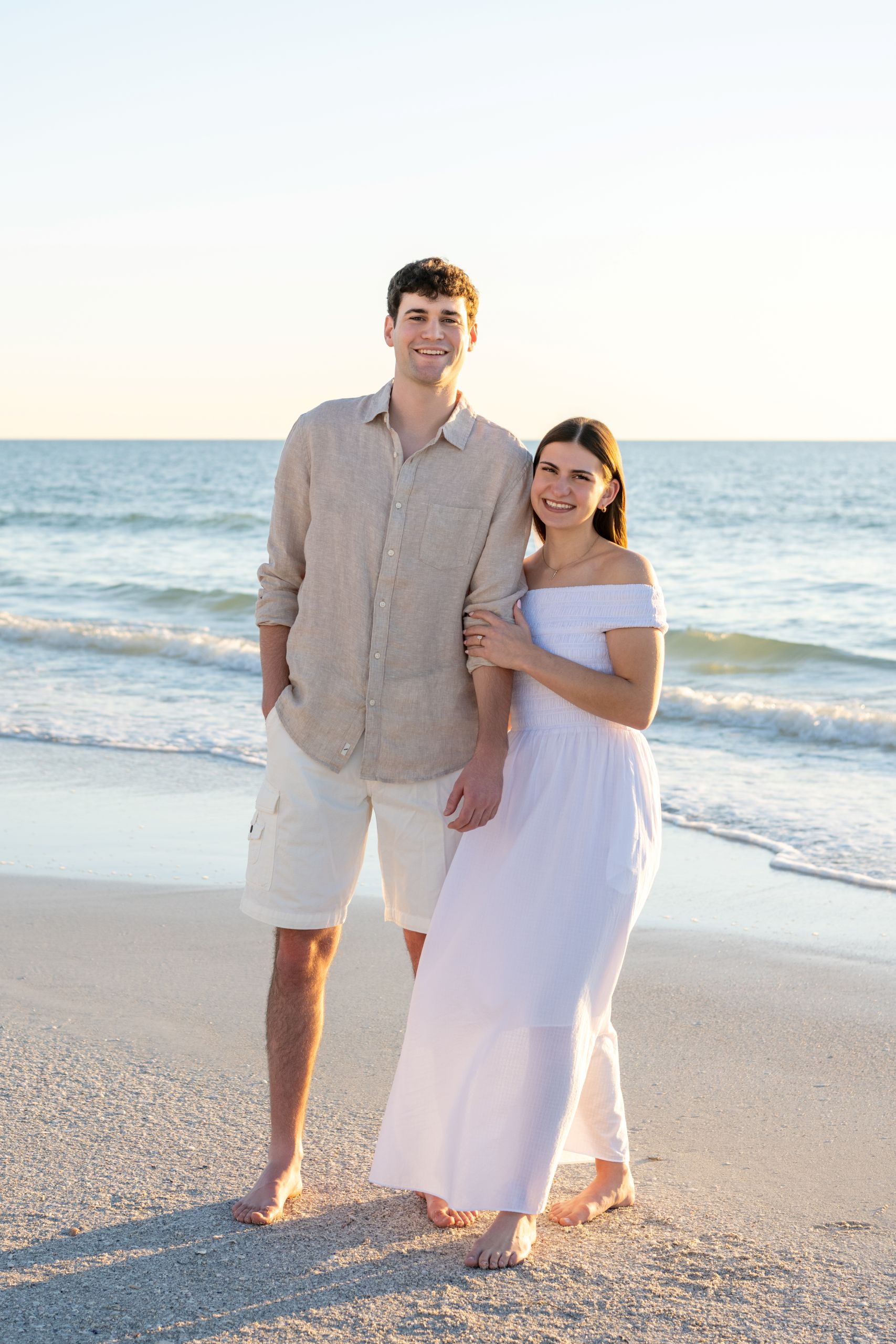 young woman holding her fiance's arm as they smile