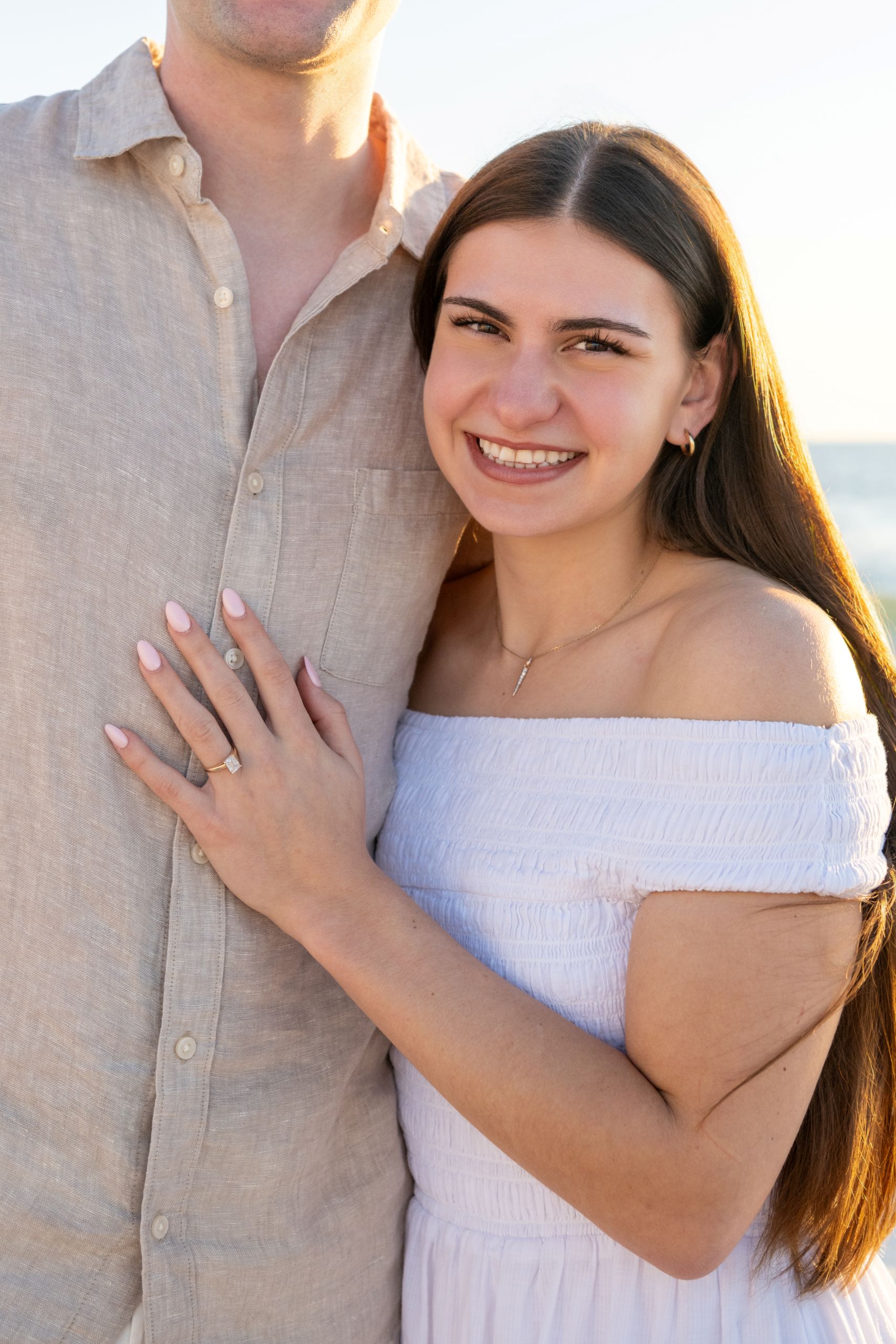 woman holding her man close and showing off her engagement ring