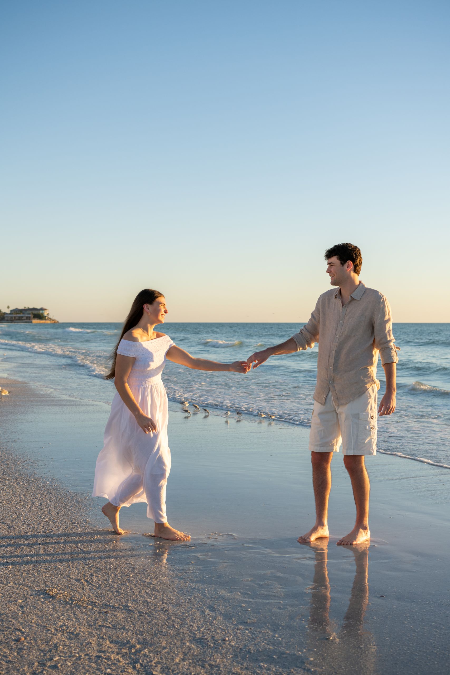 young engaged couple dance on the beach