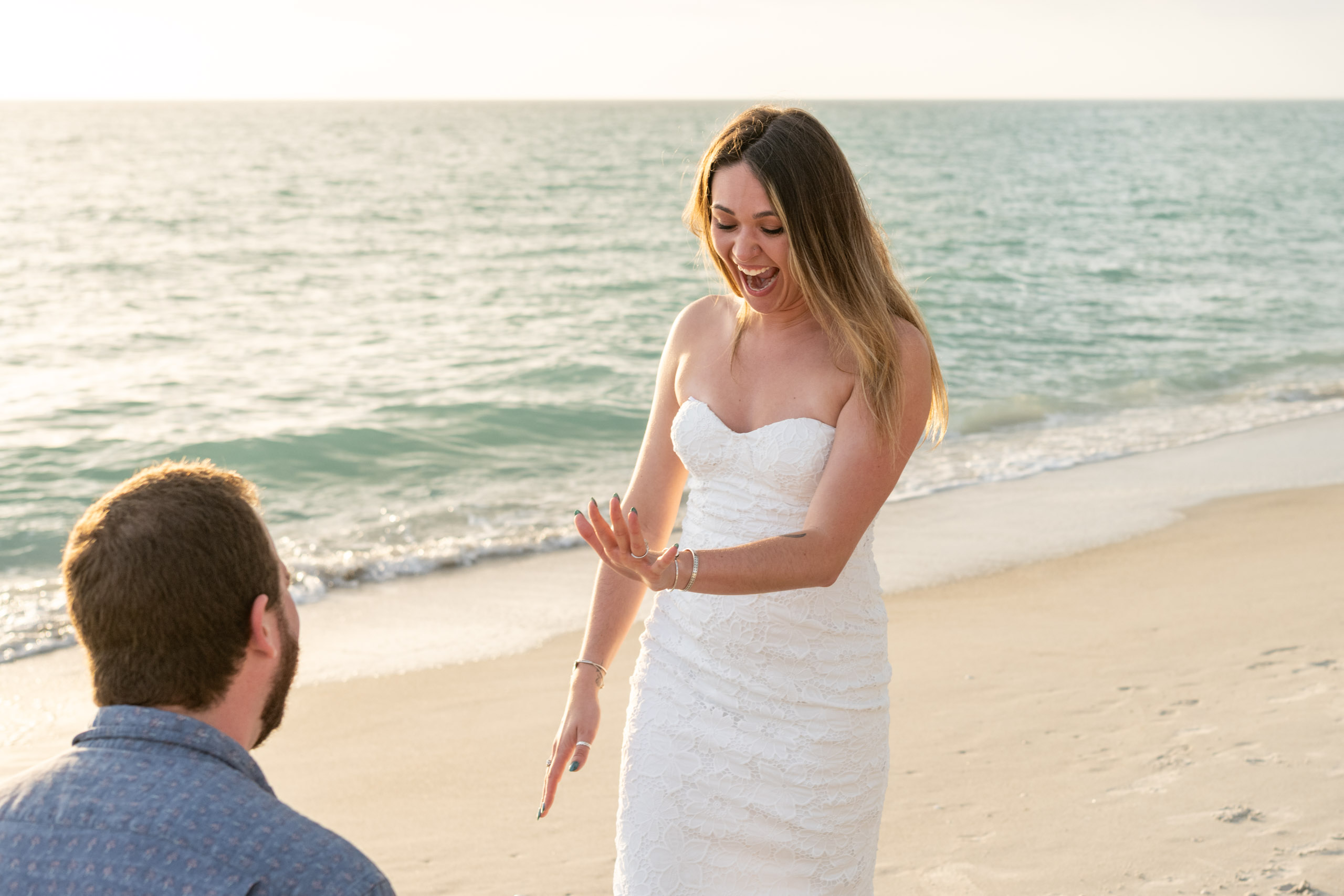 woman looks at engagement ring in surprise