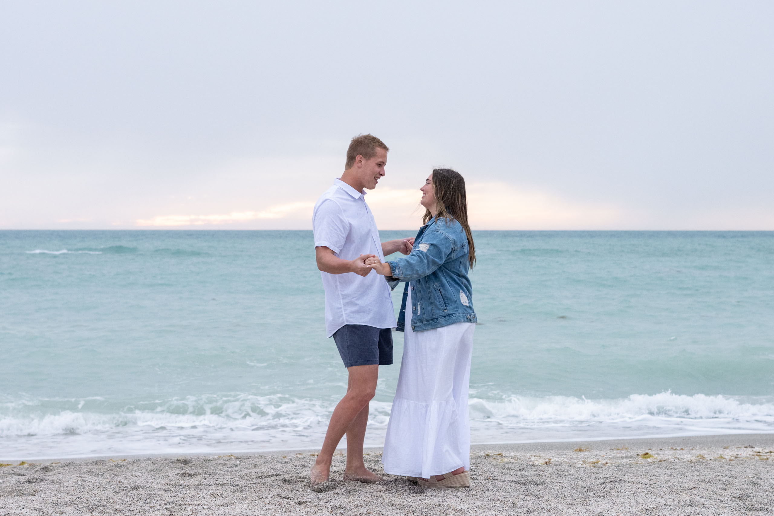 couple dance on the beach on a cloudy evening before sunset