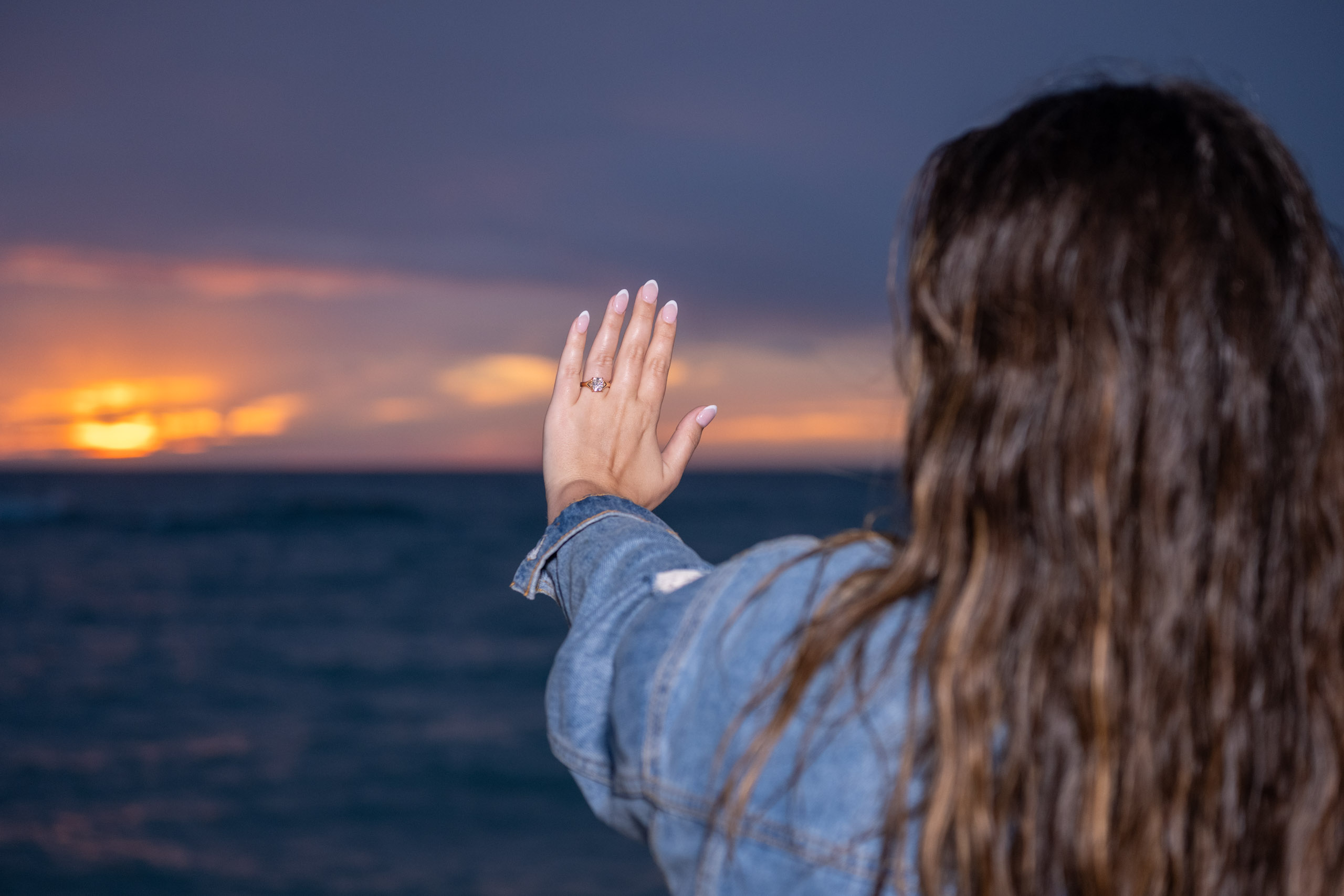 newly engaged girl admires her wedding ring
