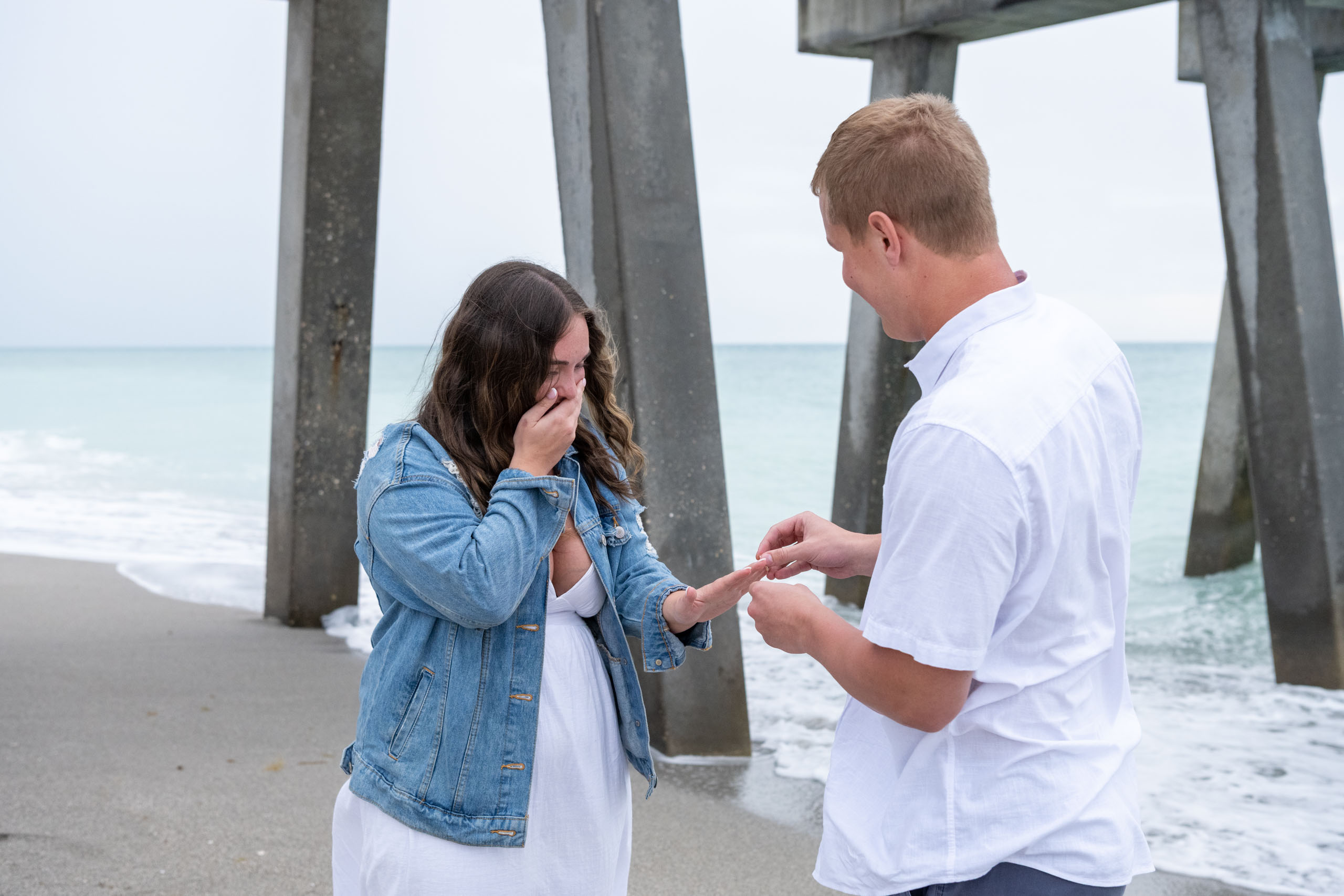 man putting engagement ring on his girlfriends finger
