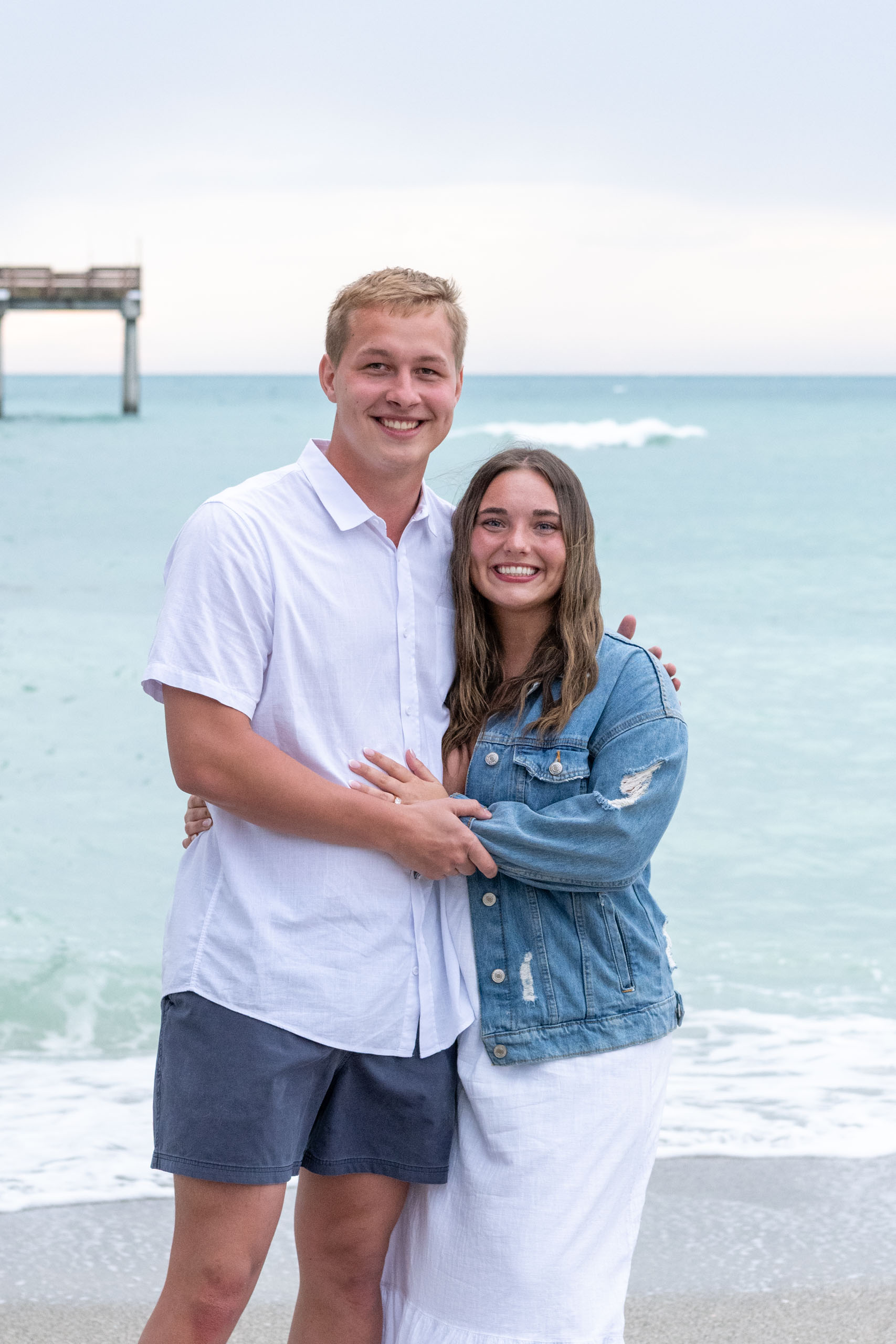 newly engaged couple smile together by the Venice Fishing Pier after engagement