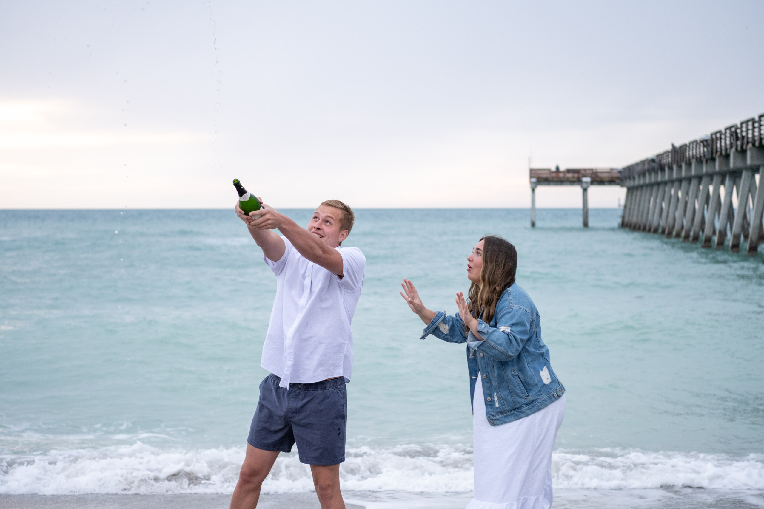 guy holds a champagne bottle in the air