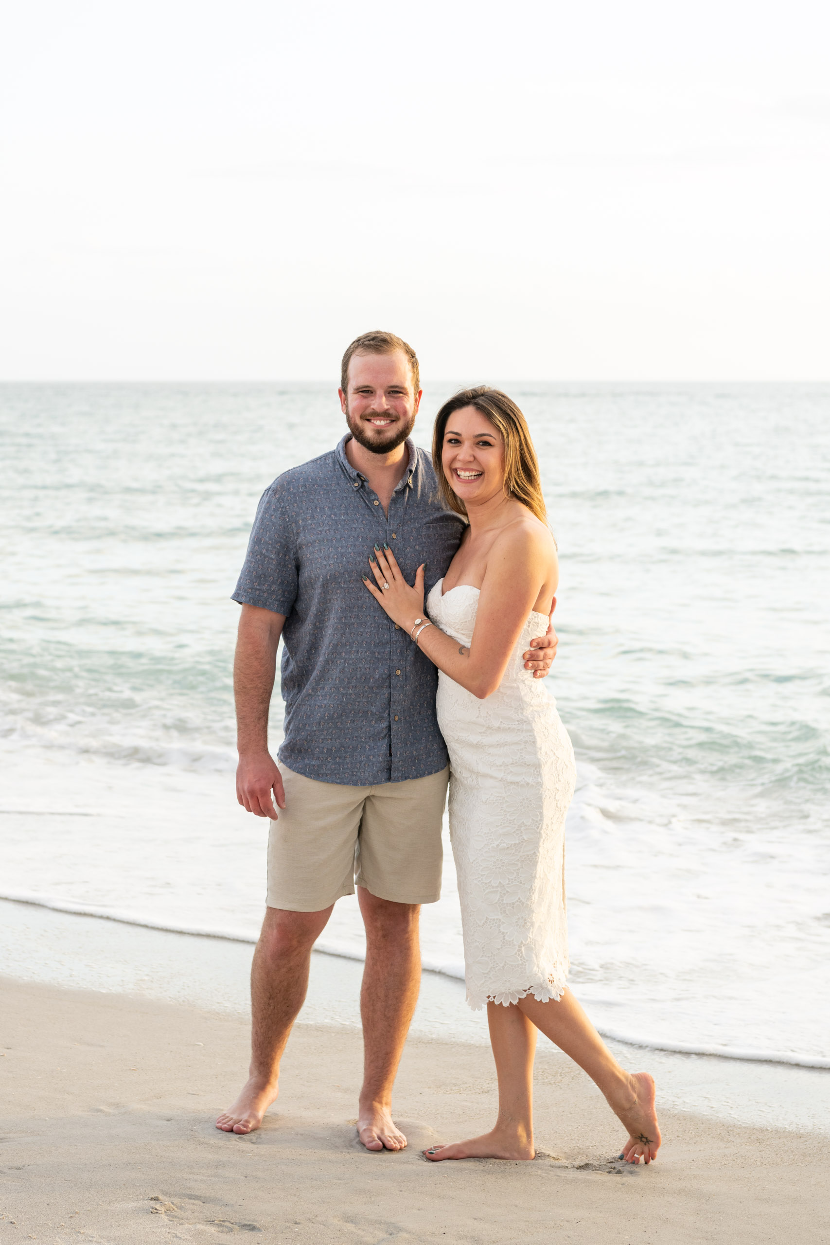 newly engaged couple smile together on Blind Pass Beach