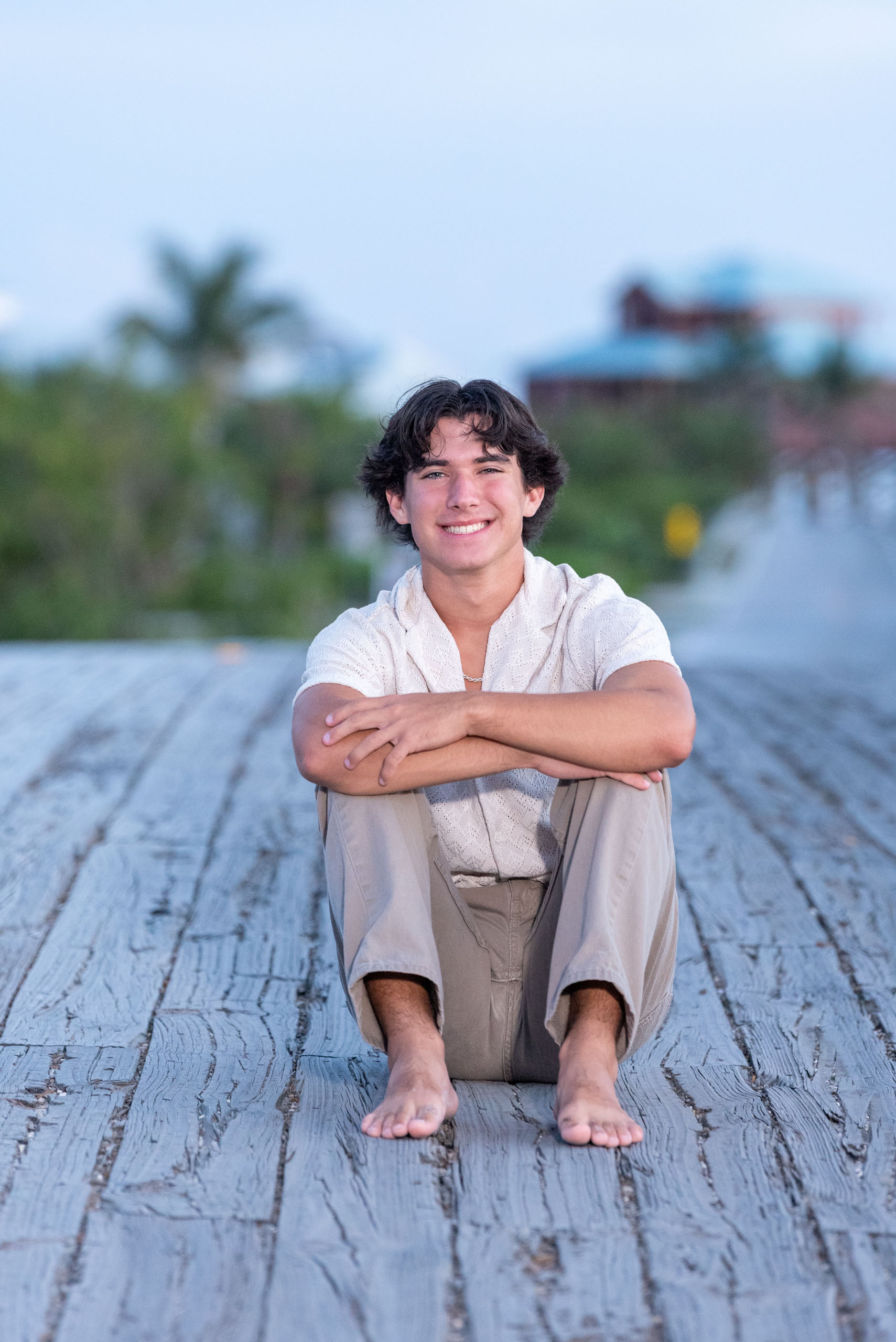 senior boy sitting on bridge