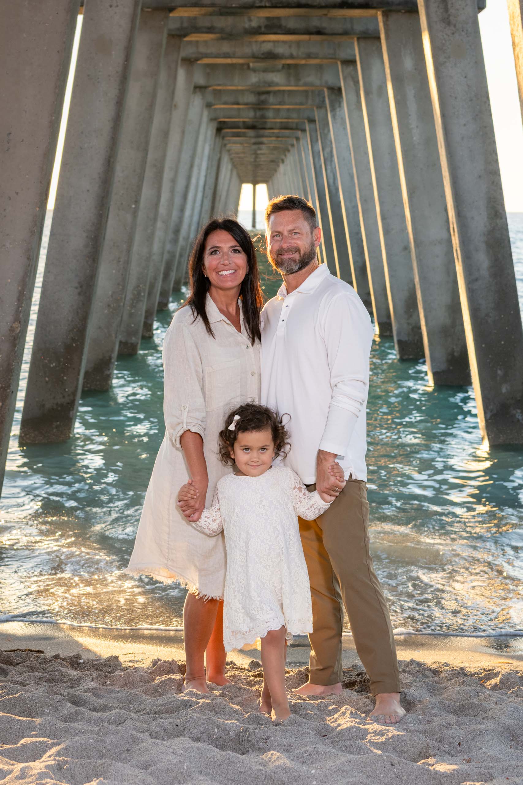 grandparents with their granddaughter under the pier