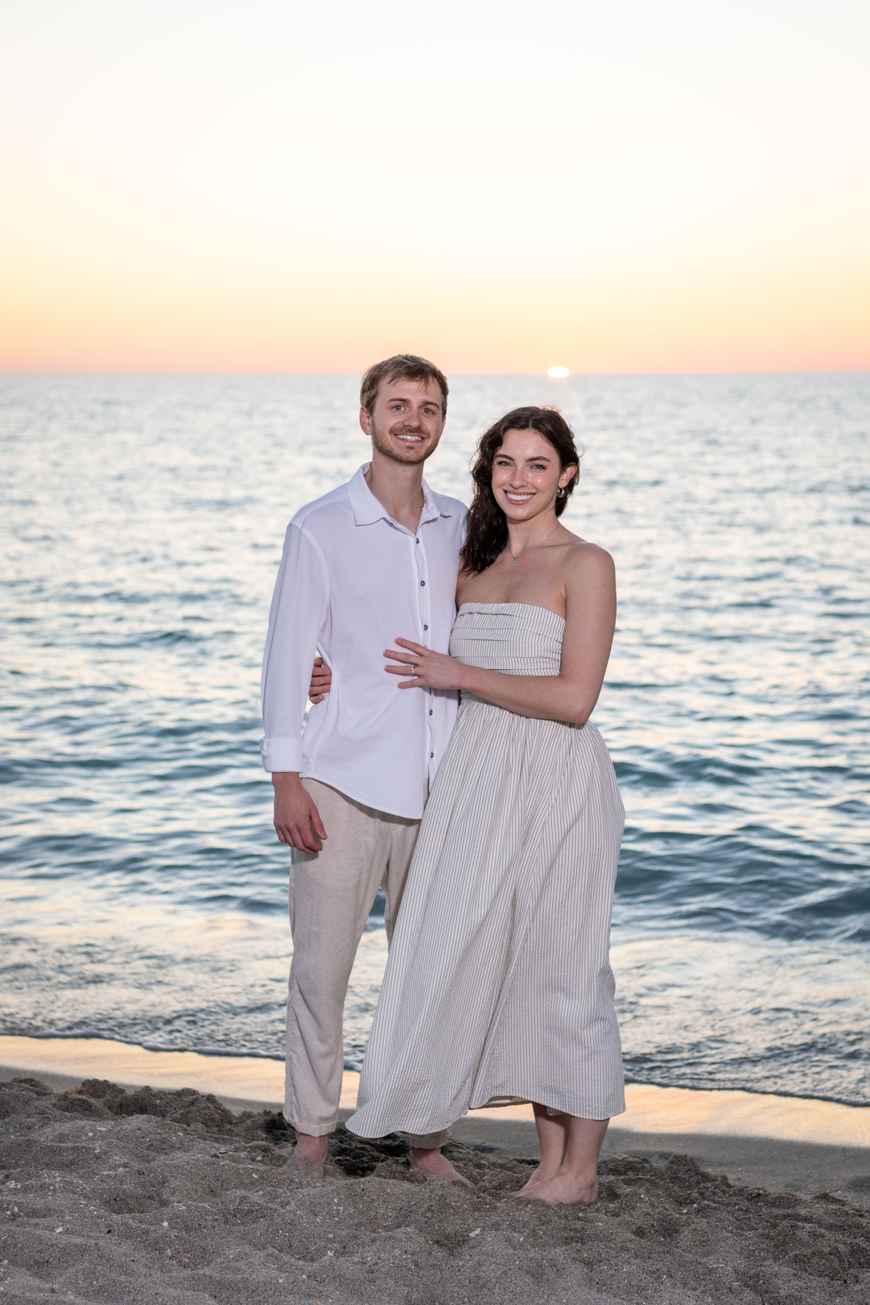 cute young married couple on the beach at sunset