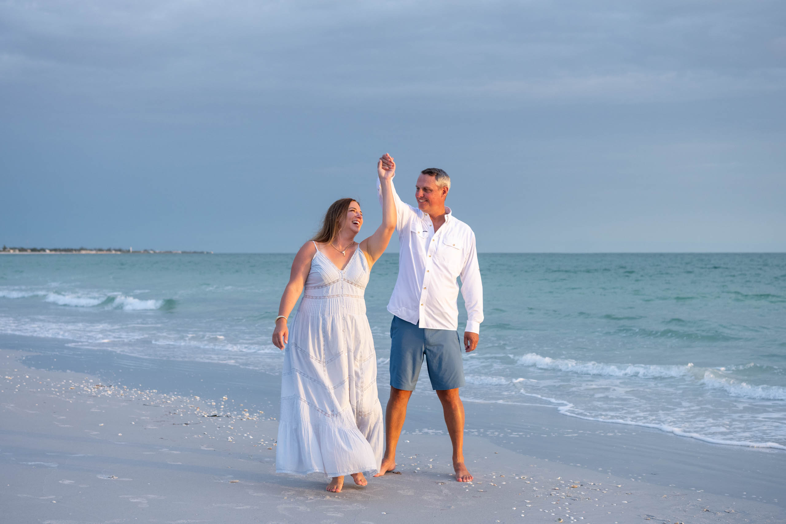 husband and wife dancing on the beach