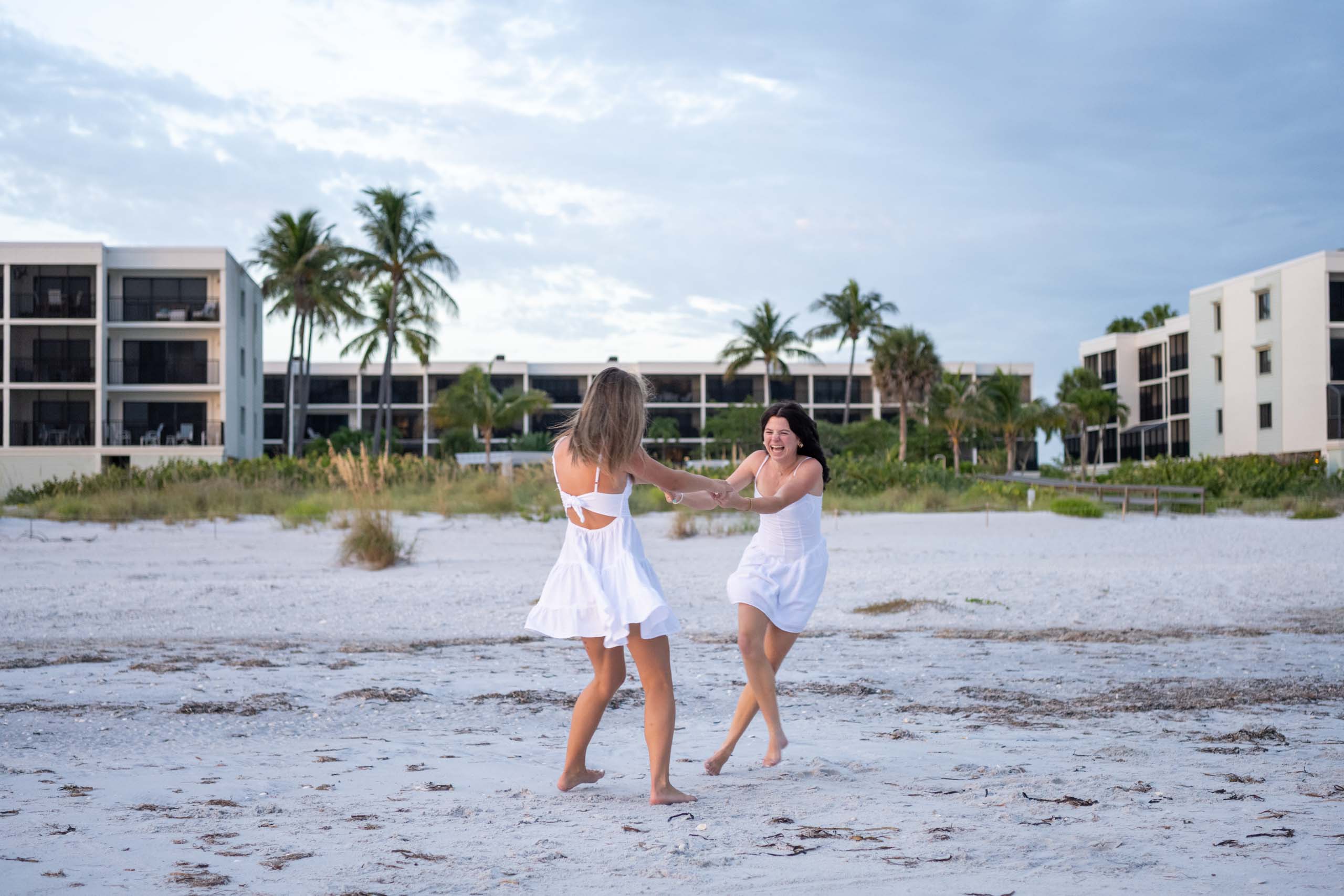 girls having fun twirling on the beach