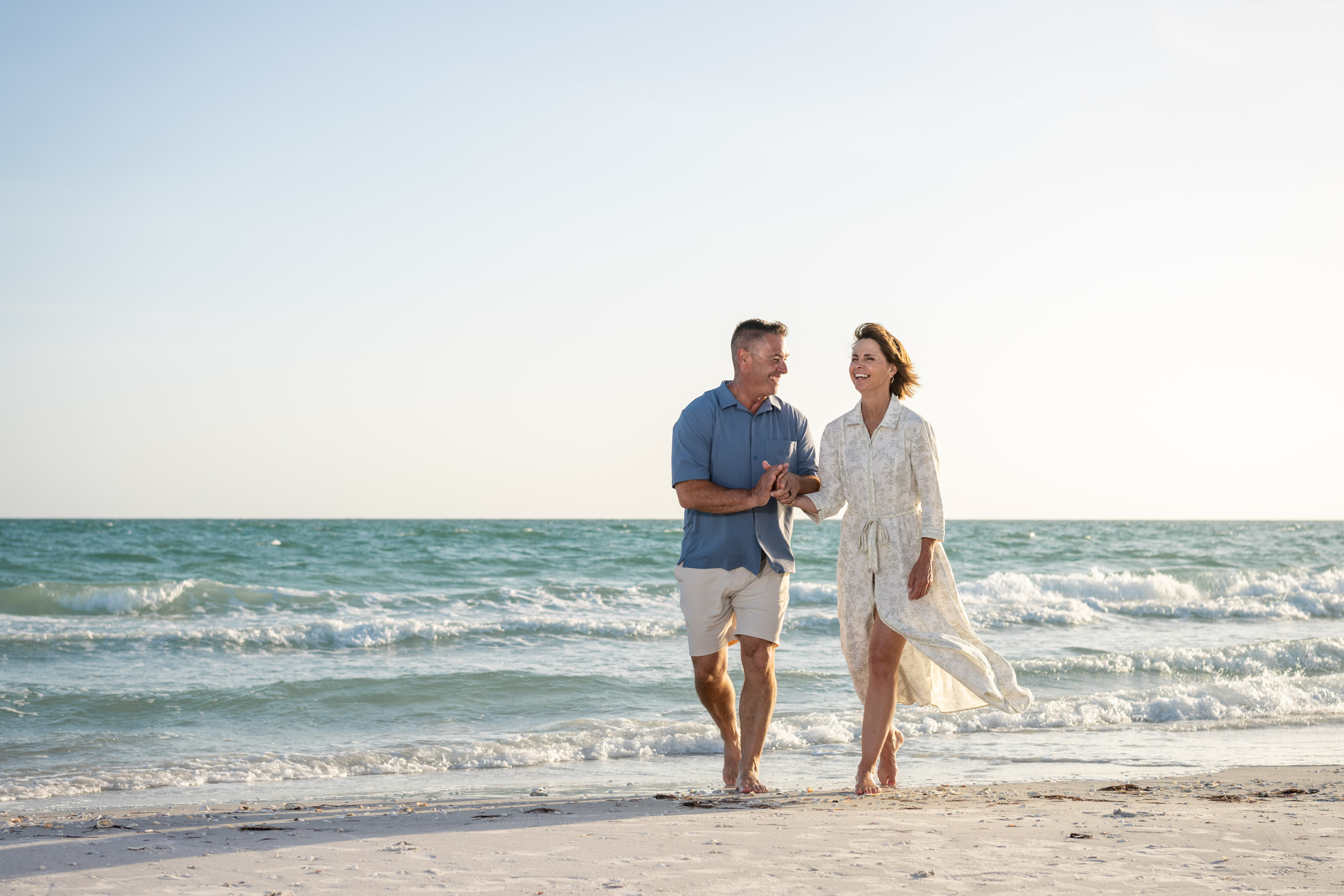 husband and wife walking along the beach