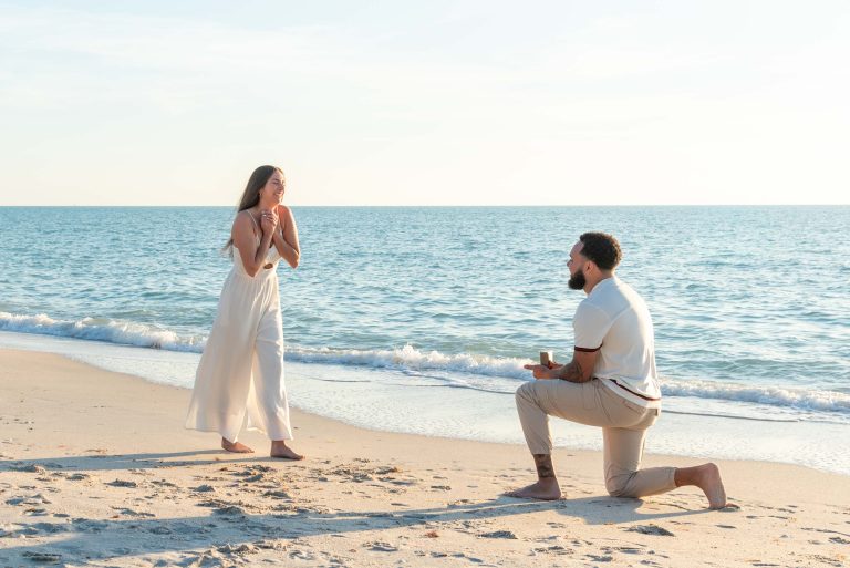 a man proposes to his girlfriend who brings her arms to her chest in surprise