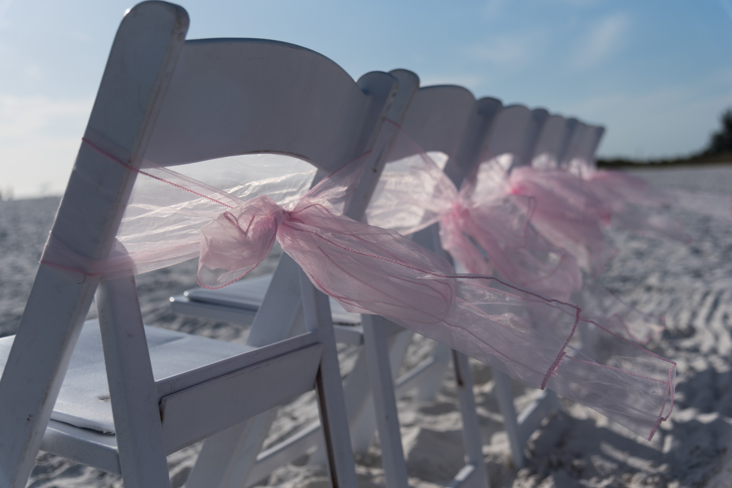 pink ribbons tied to the chairs