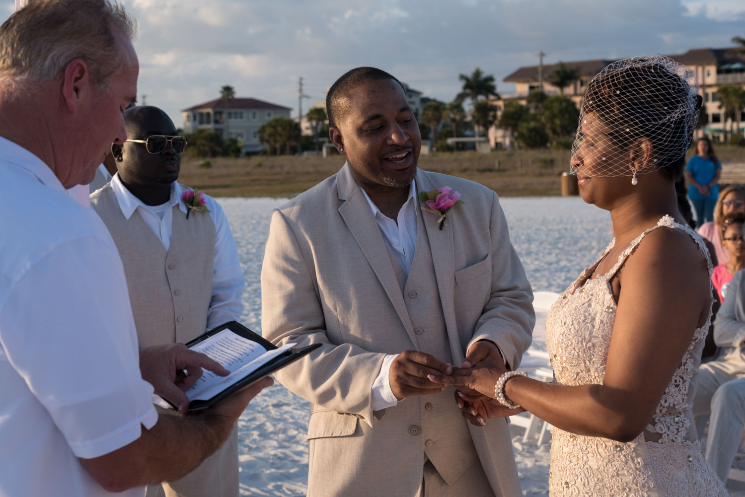 groom puts wedding ring on bride's finger