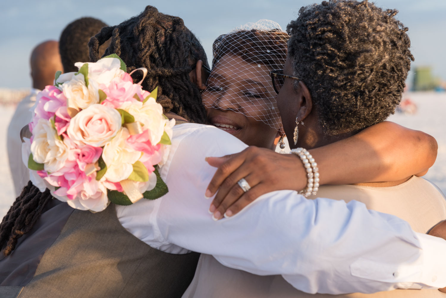 bride hugs her mother and brother