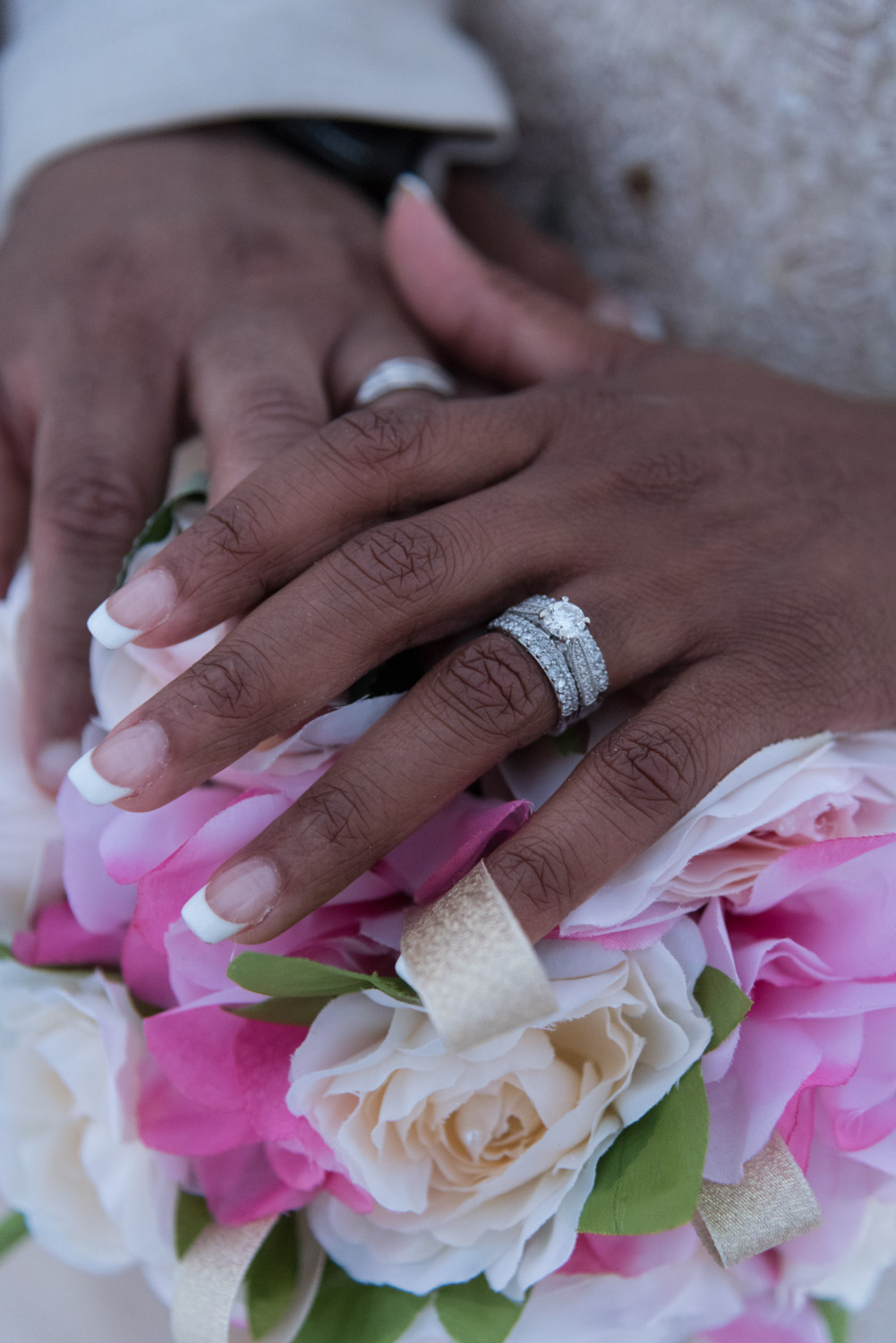 bride and groom show off their wedding rings
