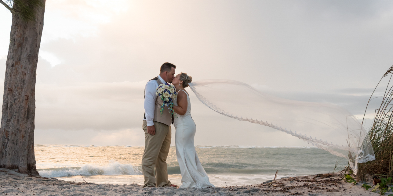 bride and groom kiss at sunset on the beach at Palm Island Resort