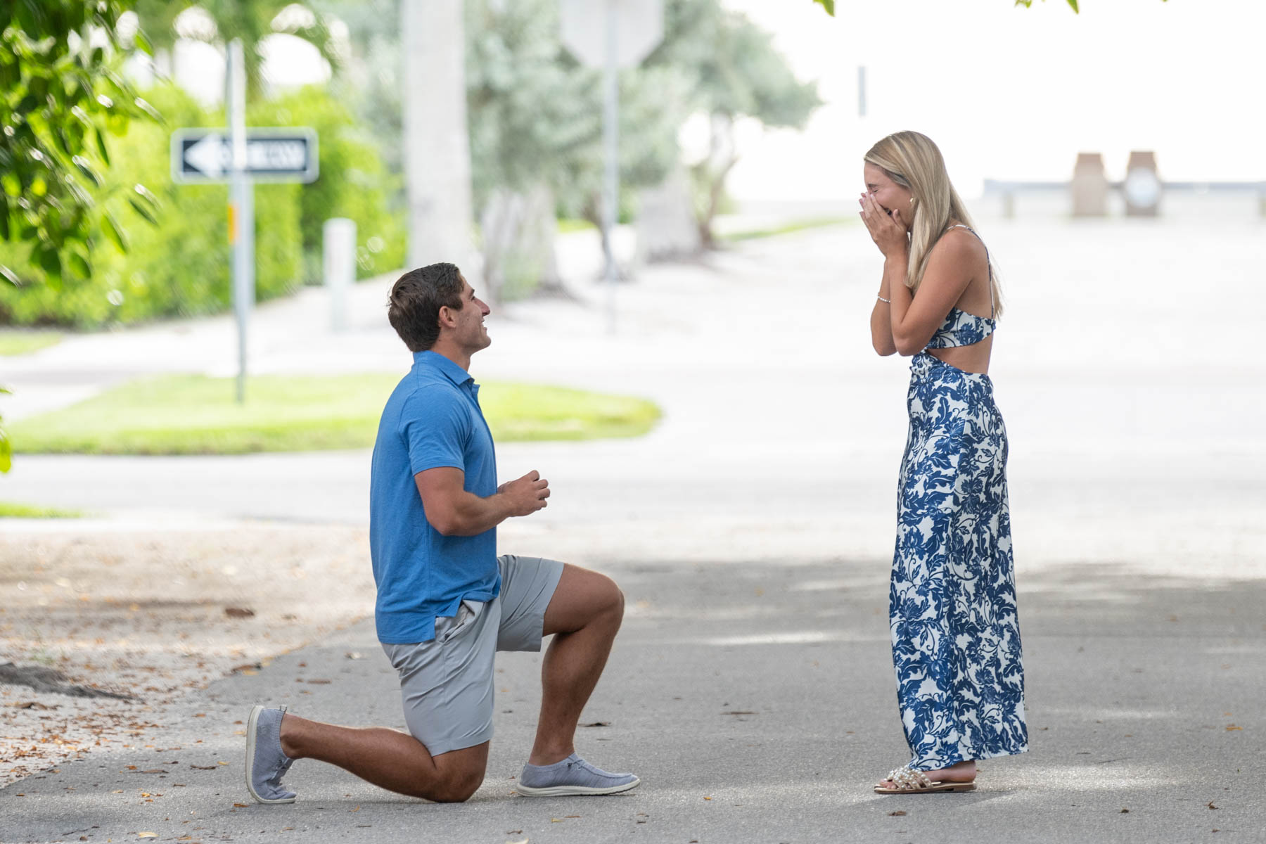 guy gets down on knee to propose to girlfriend as they stand on Banyan Street on Boca Grande