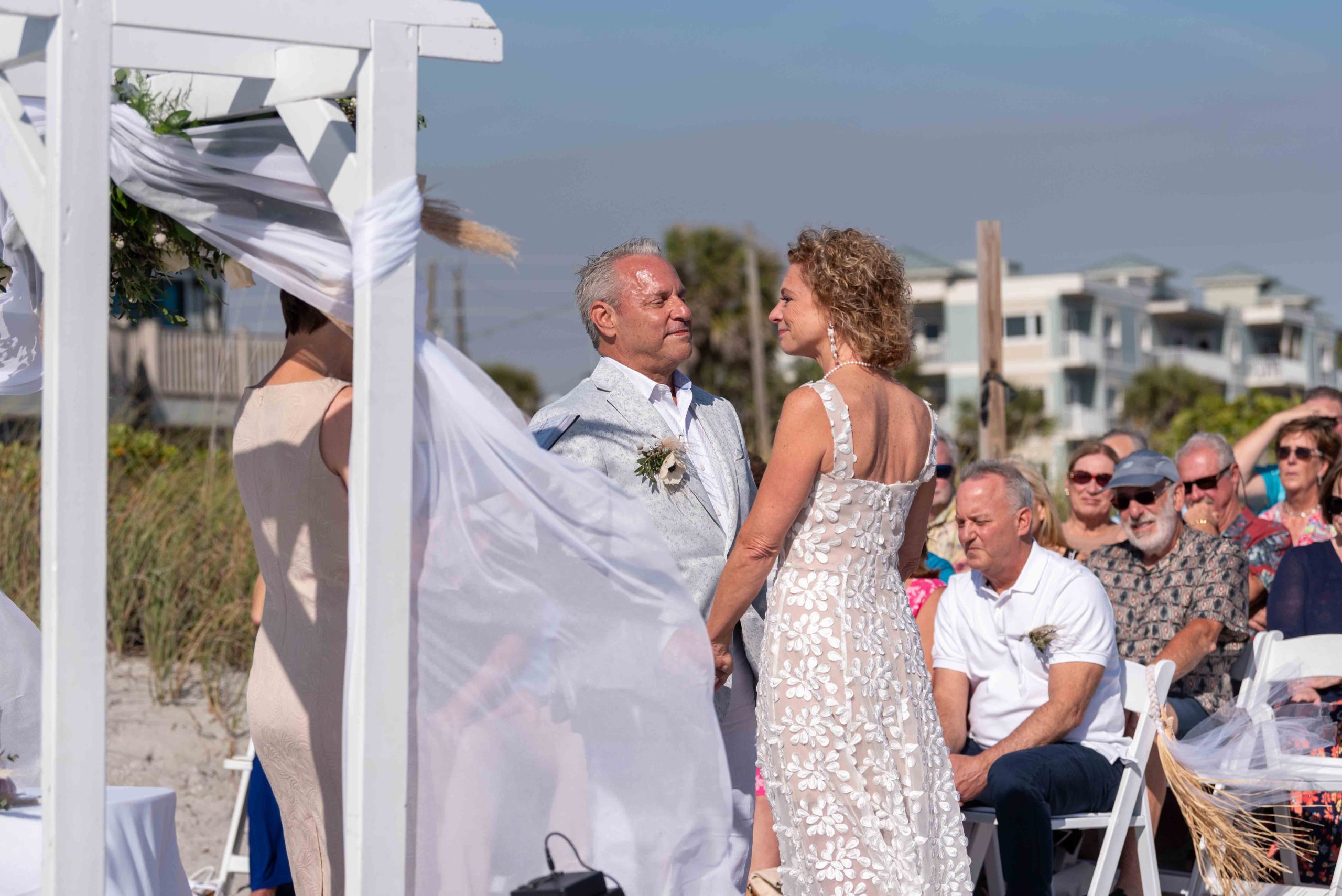 groom looks lovingly at his wife during ceremony on Englewood Beach