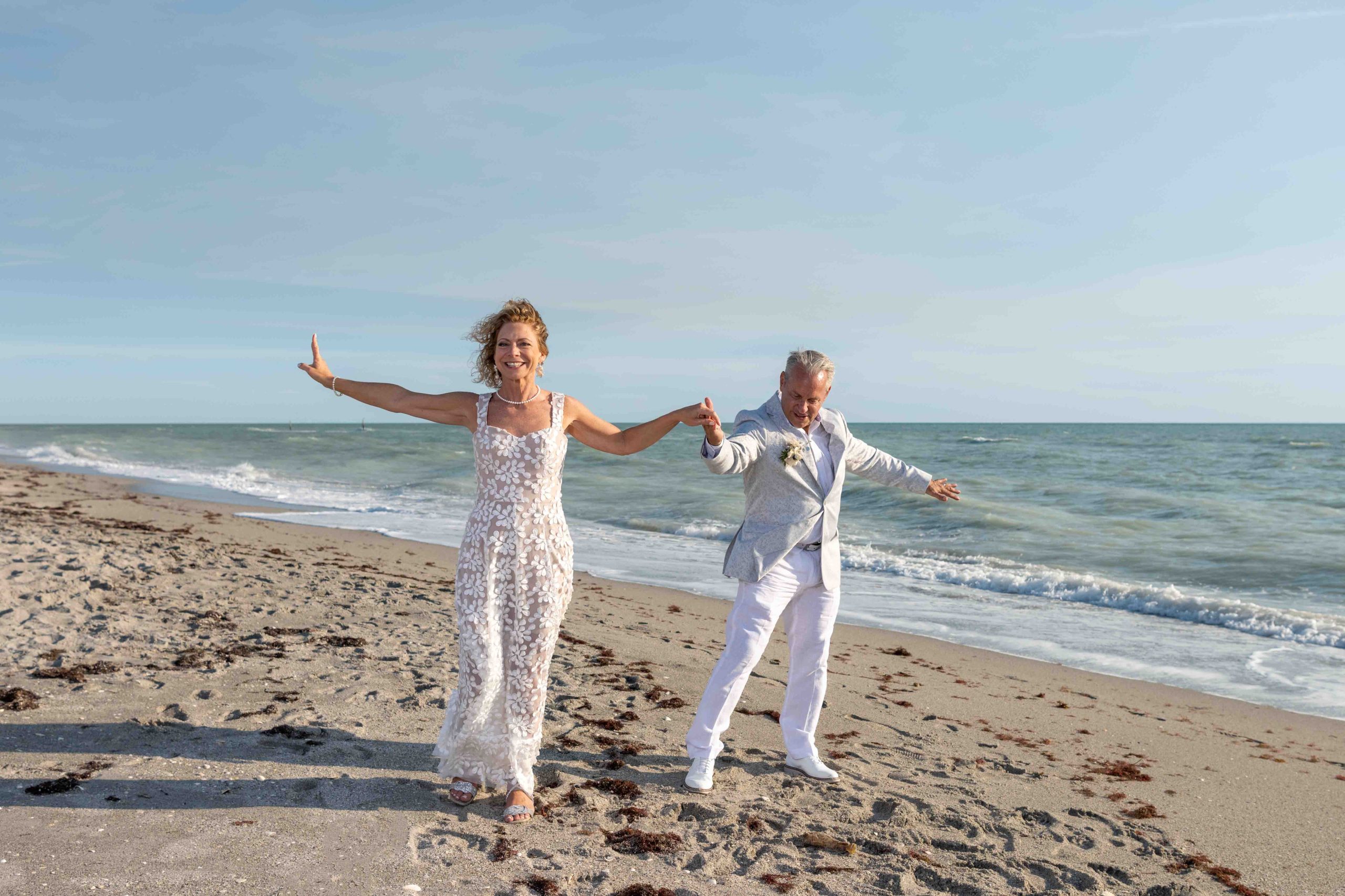 bride and groom practice dancing on the beach before the reception