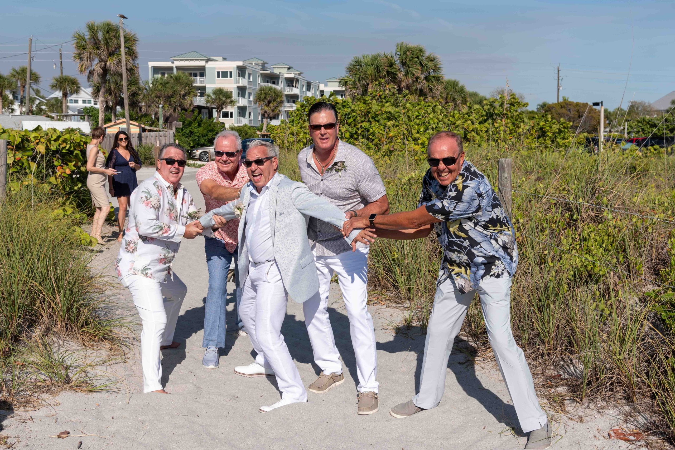 groom jokingly being held back by his male friends