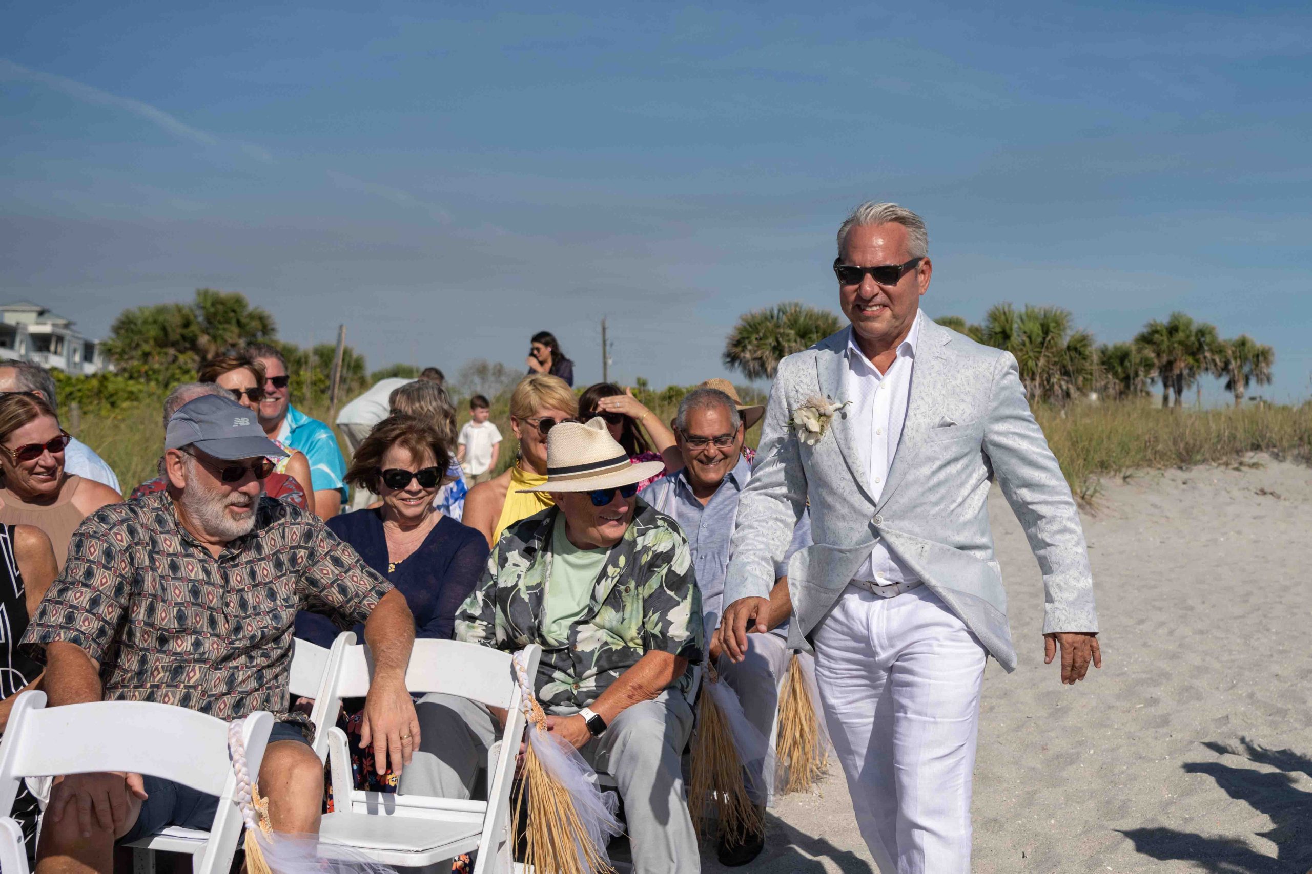 groom has a big smile as he walks down the aisle