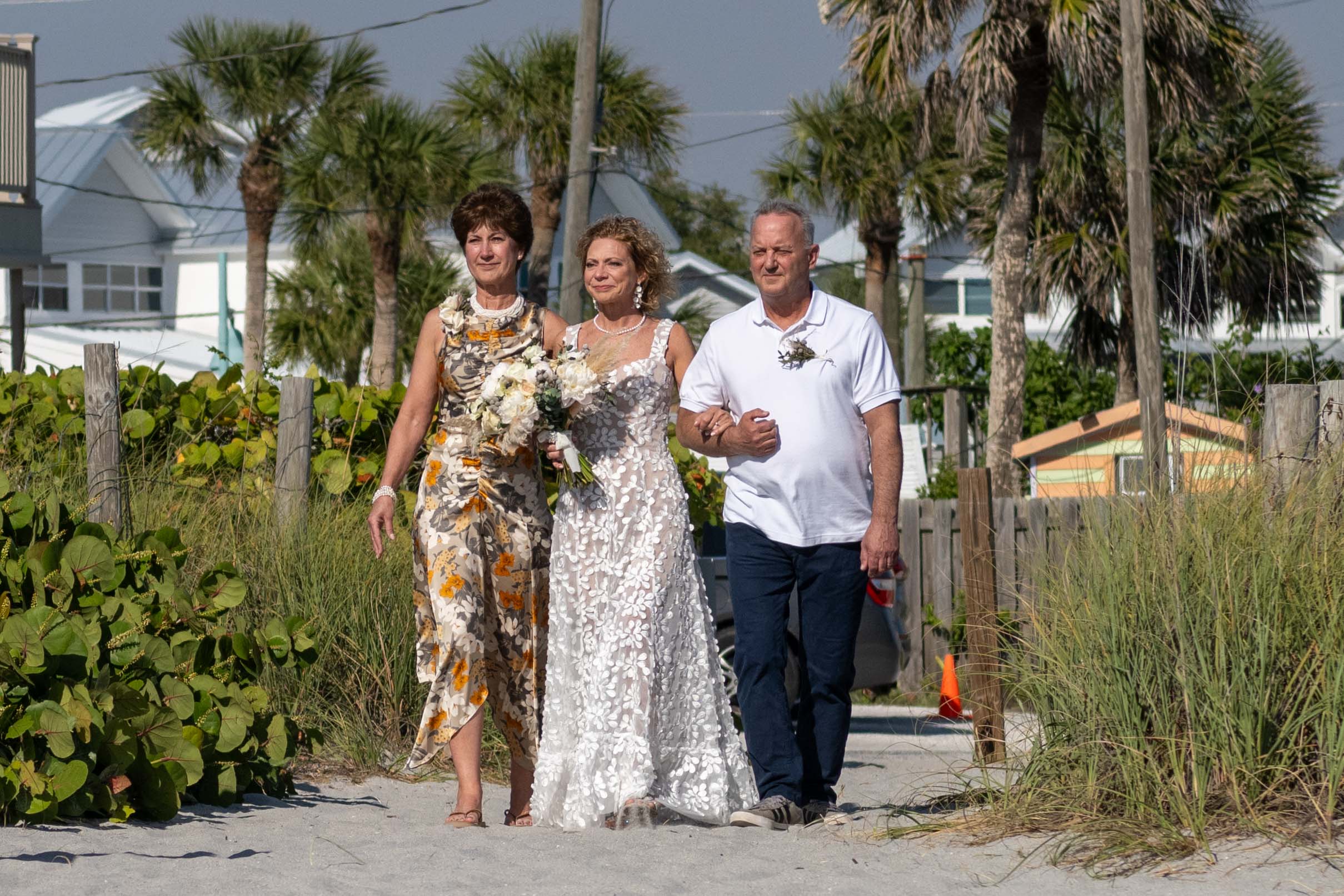 bride is escorted to the wedding by her sister and brother