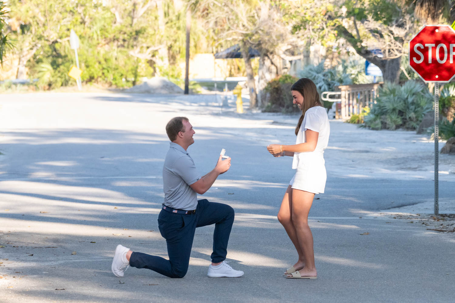 Boca Grande surprise proposal photo with guy on his knee on Banyan street asking his girlfriend to marry him