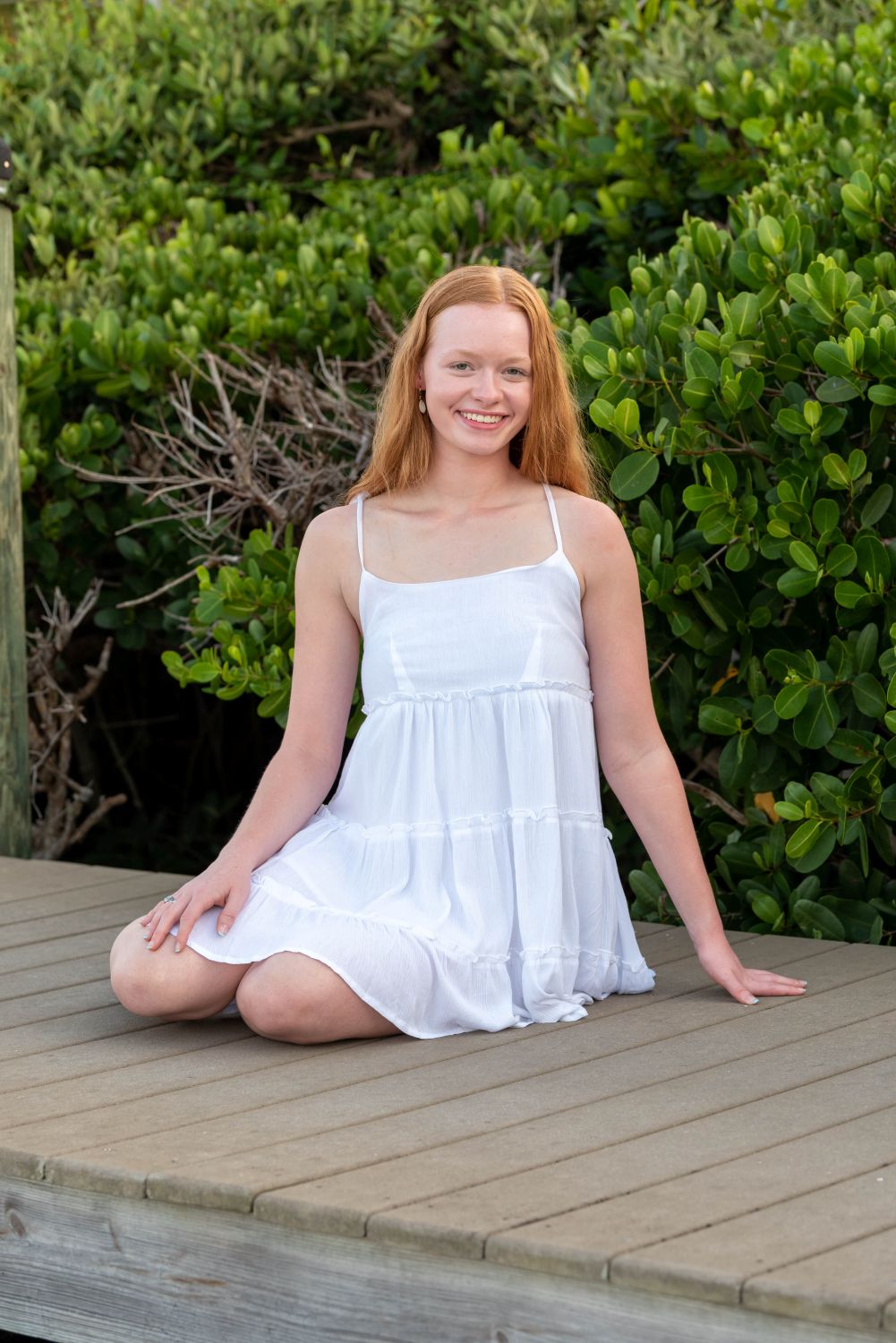 senior photo of girl on boardwalk with mangroves behind her