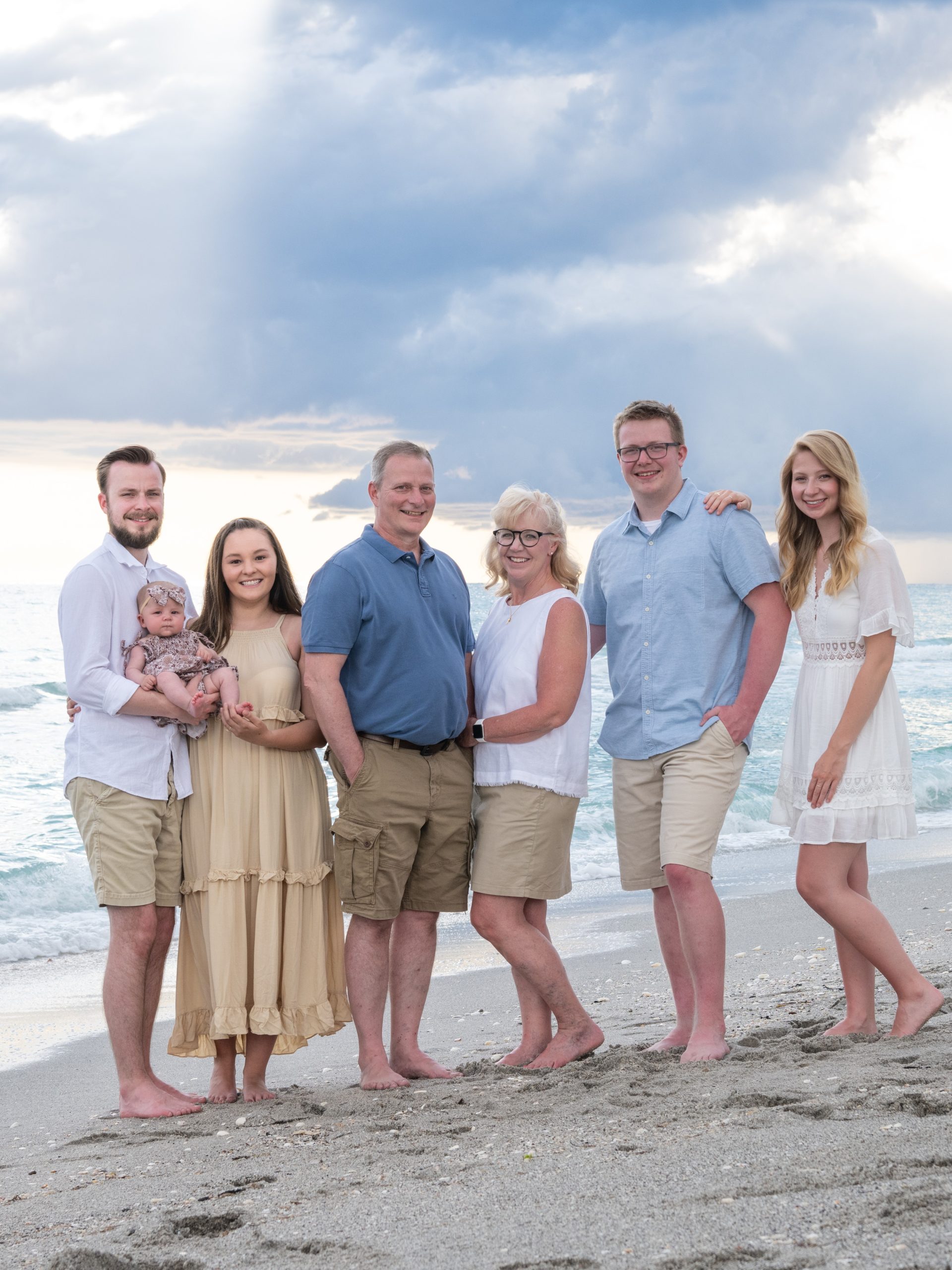grandparents with their children and granddaughter by the water