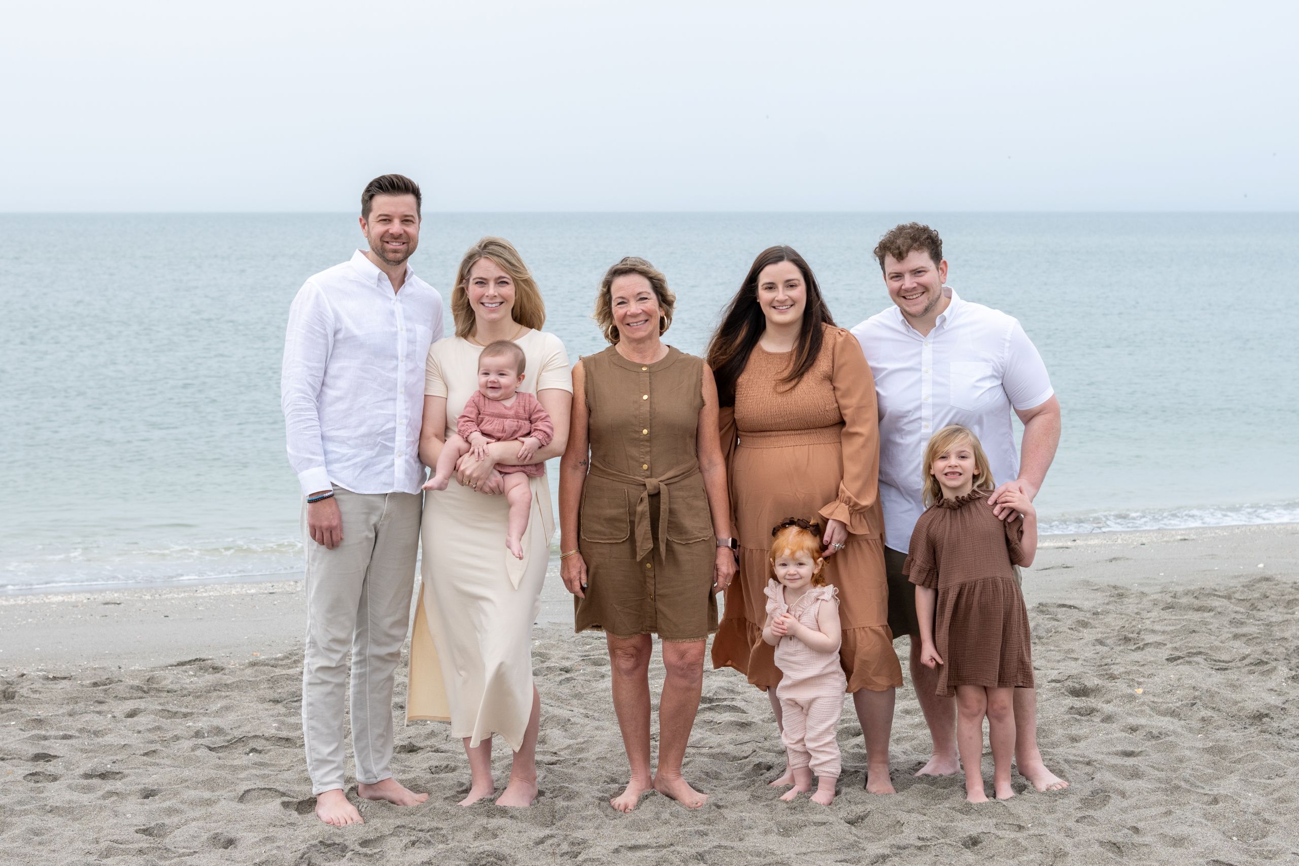 family photo on the beach at sunrise with three generations of family