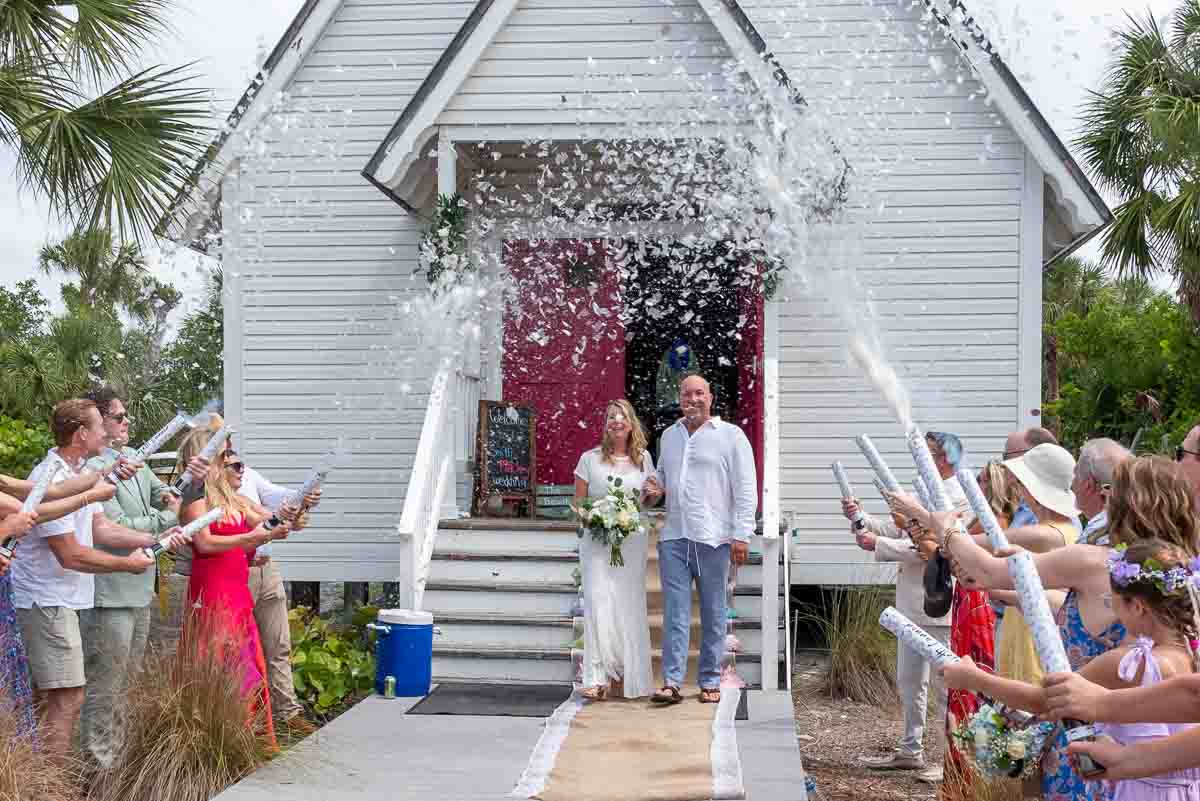 bride and groom exit the chapel on Little Gasparilla Island and guests celebrate with confetti
