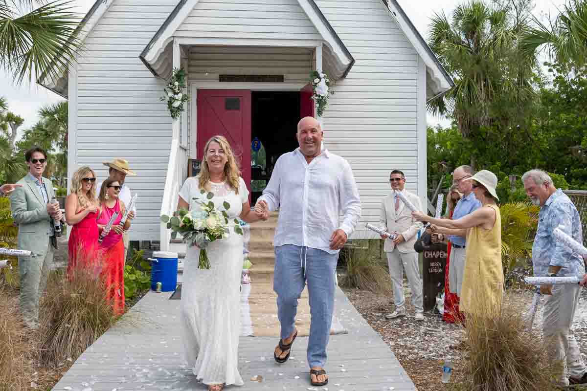 bride and groom smile as they make their way out of church