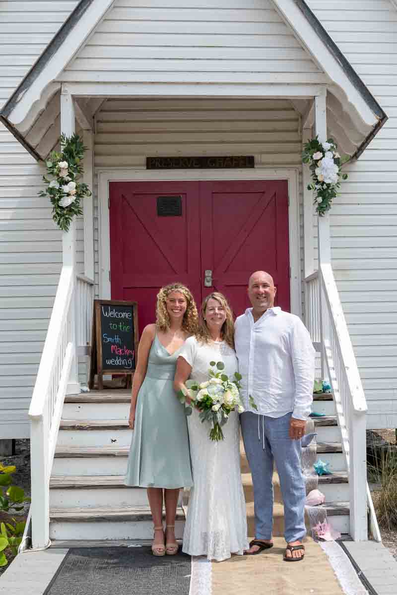 couple with their daughter in front of the chapel